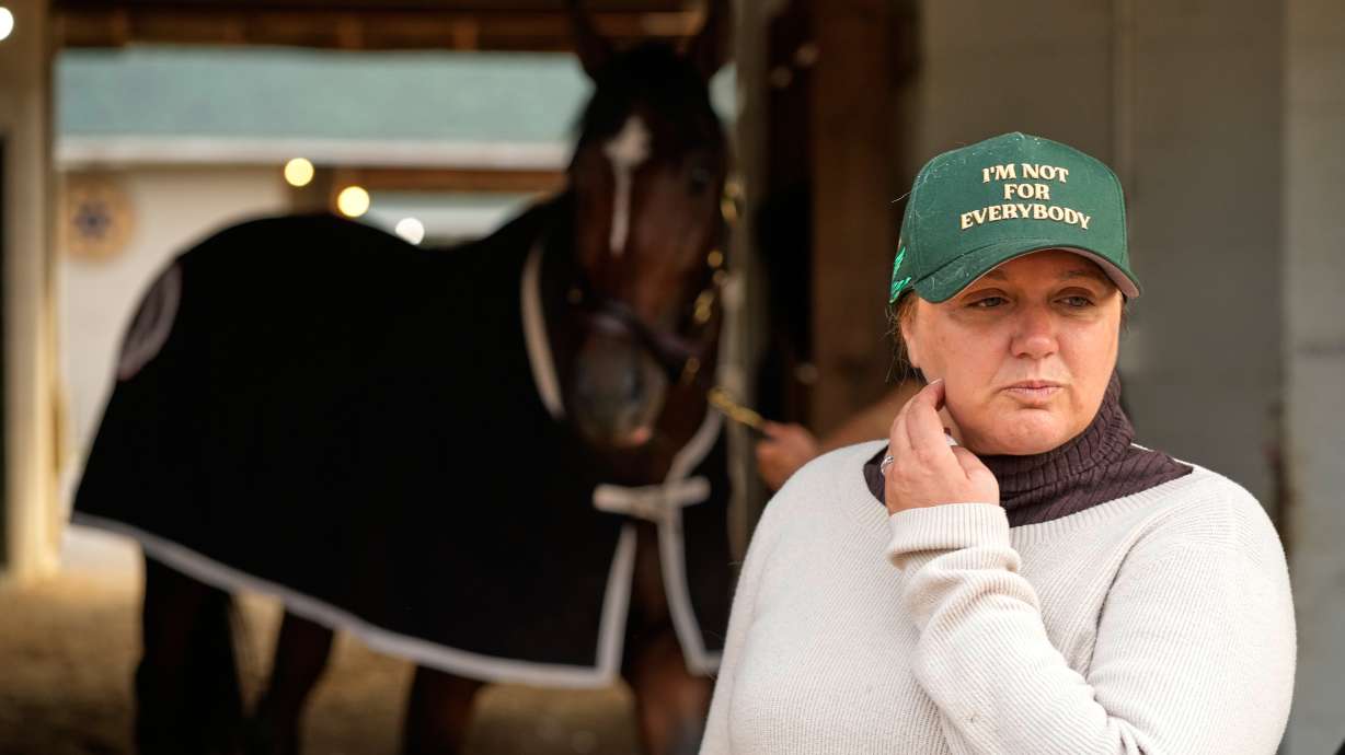 Trainer Cherie DeVaux stands watches from a barn after a workout at Churchill Downs Monday, April 27, 2026, in Louisville, Ky.