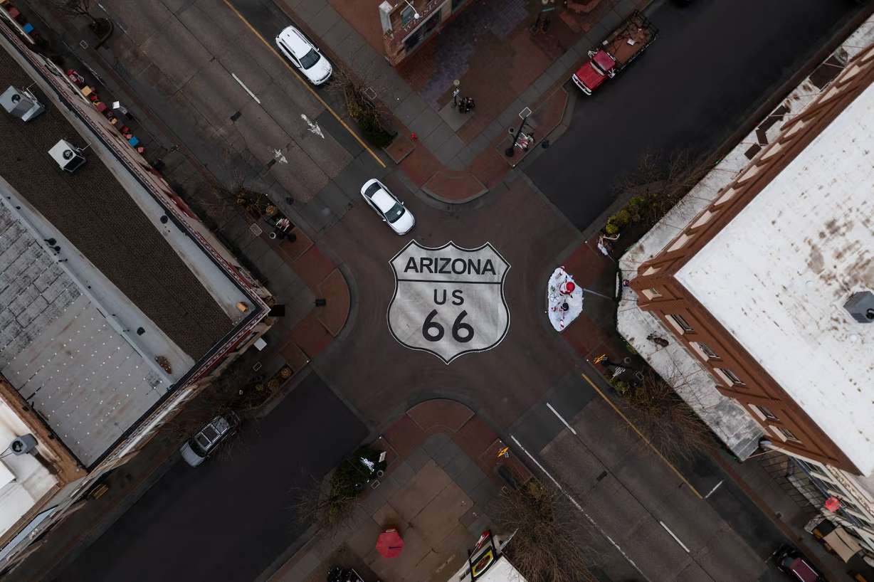 Motorists travel through an intersection marked with a U.S. 66 shield in Winslow, Ariz., a town on the historic highway, Nov. 20, 2025.