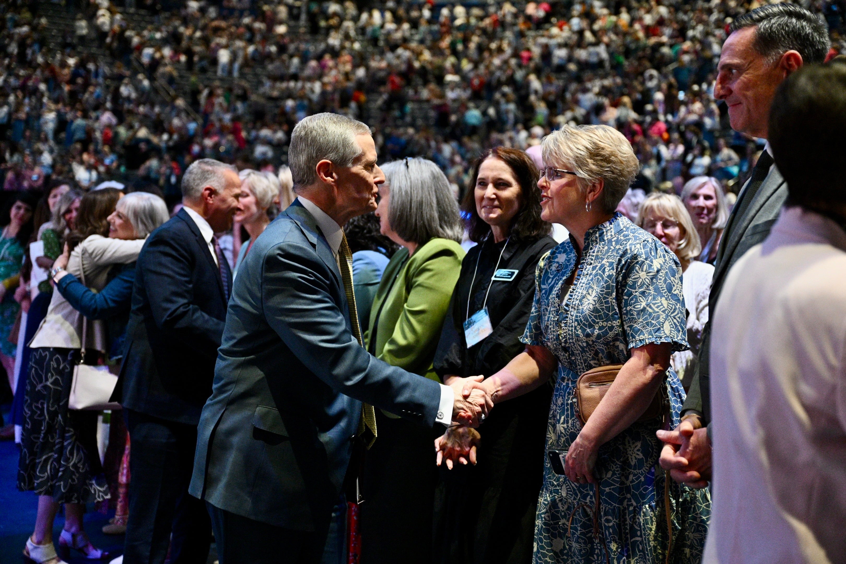 Elder David A. Bednar of the Quorum of the Twelve Apostles greets attendees during the closing keynote for BYU Women's Conference in the Marriott Center in Provo on Friday. Elder Bednar spoke of his experience ministering to victims of the Michigan meetinghouse attack with his wife, Susan.
