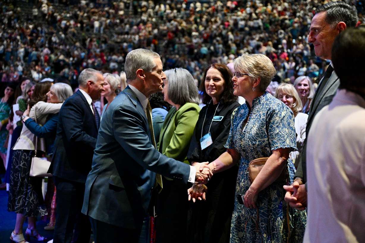 Elder David A. Bednar of the Quorum of the Twelve Apostles greets attendees during the closing keynote for BYU Women's Conference in the Marriott Center in Provo on Friday. Elder Bednar spoke of his experience ministering to victims of the Michigan meetinghouse attack with his wife, Susan.