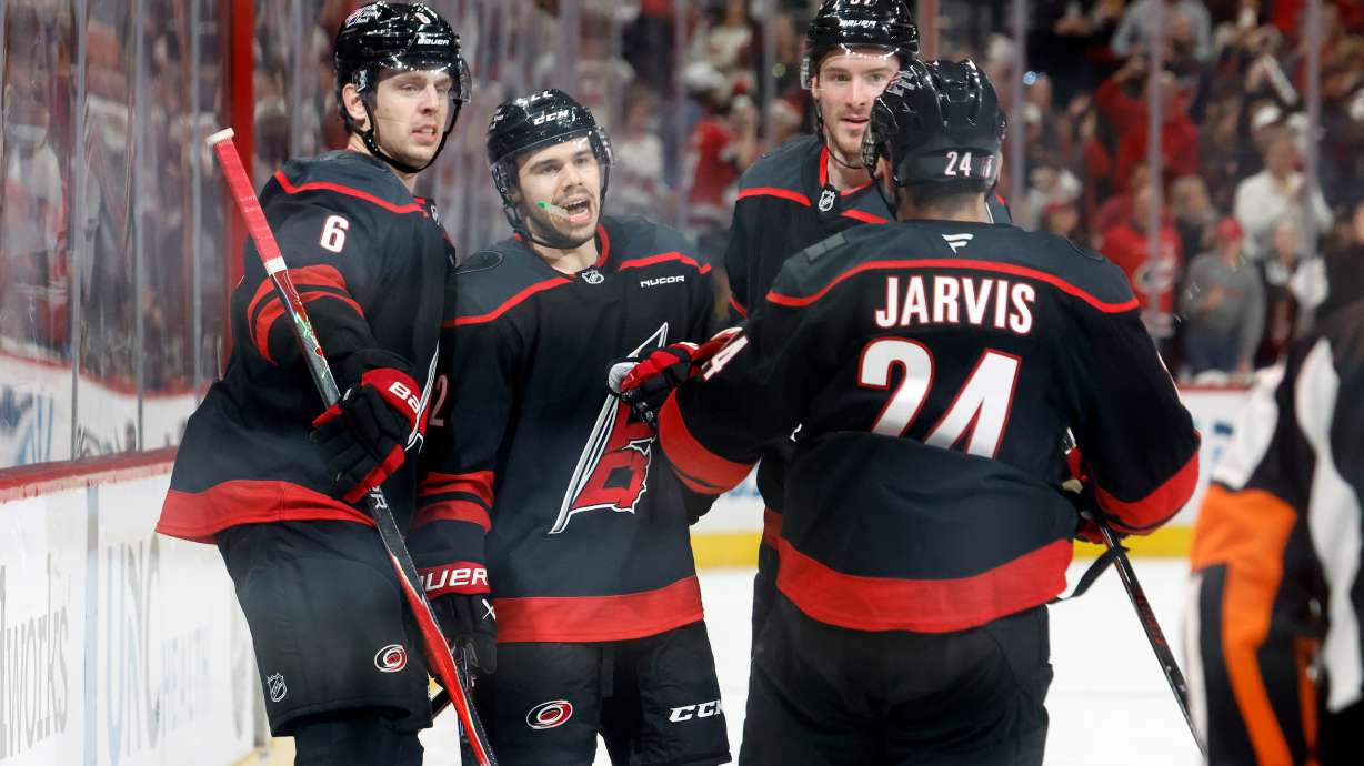 Carolina Hurricanes' Logan Stankoven (22) celebrates after his second goal with teammates Mike Reilly (6), Andrei Svechnikov, back right, and Seth Jarvis (24) during the second period of Game 1 of an NHL hockey Stanley Cup second-round playoff series against the Philadelphia Flyers in Raleigh, N.C., Saturday, May 2, 2026.