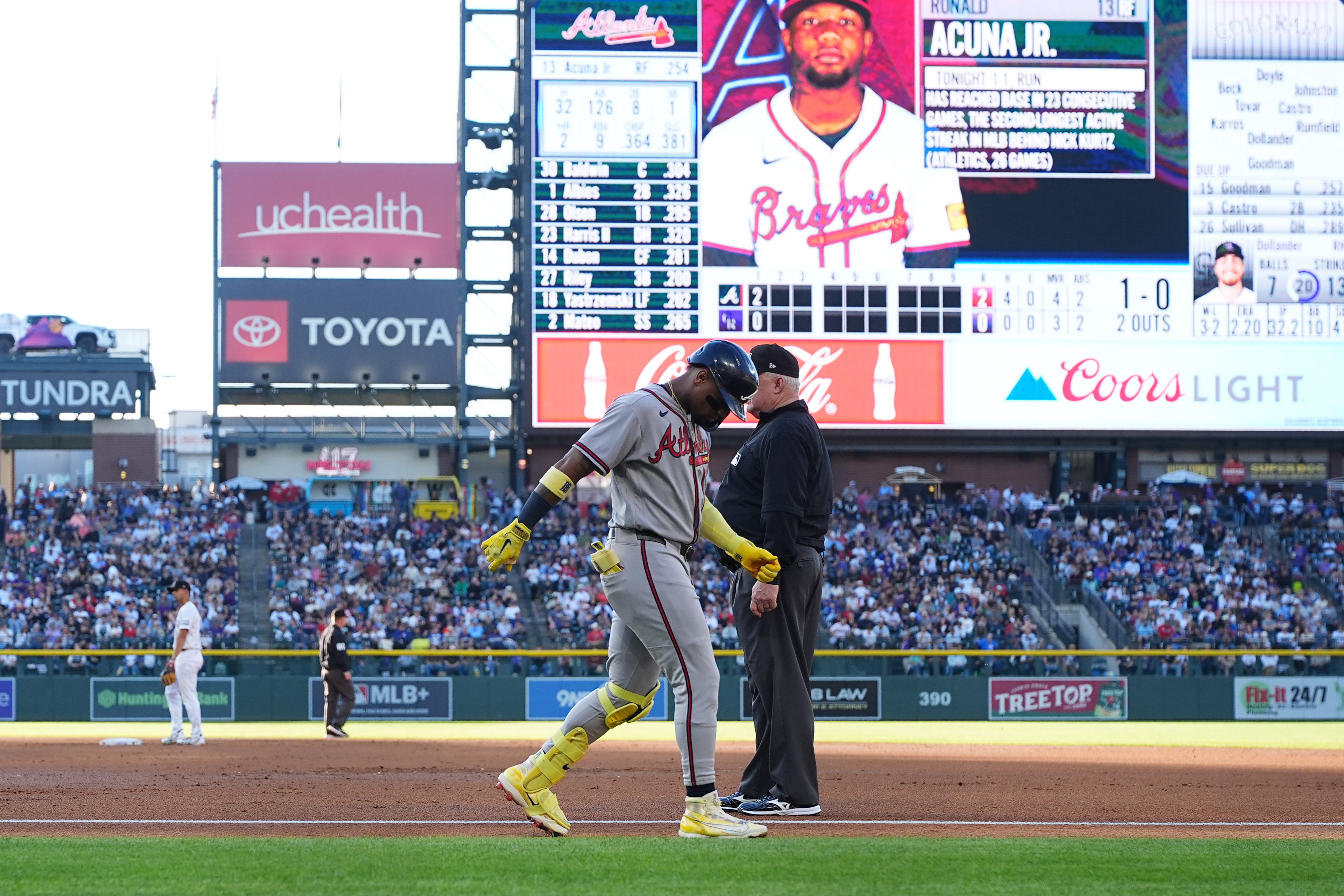 Atlanta Braves' Ronald Acuña Jr., center left, walks gingerly after being injured while running out a groundout as first base umpire Bill Miller, center right, looks on in the second inning of a baseball game against the Colorado Rockies, Saturday, May 2, 2026, in Denver. 