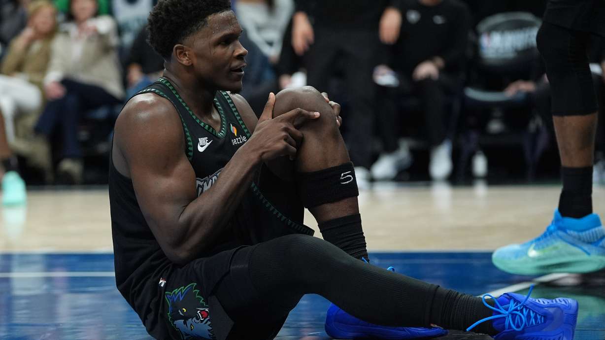 Minnesota Timberwolves guard Anthony Edwards grabs his knee after an injury during the first half of Game 4 of a first-round NBA basketball playoff series against the Denver Nuggets, Saturday, April 25, 2026, in Minneapolis.