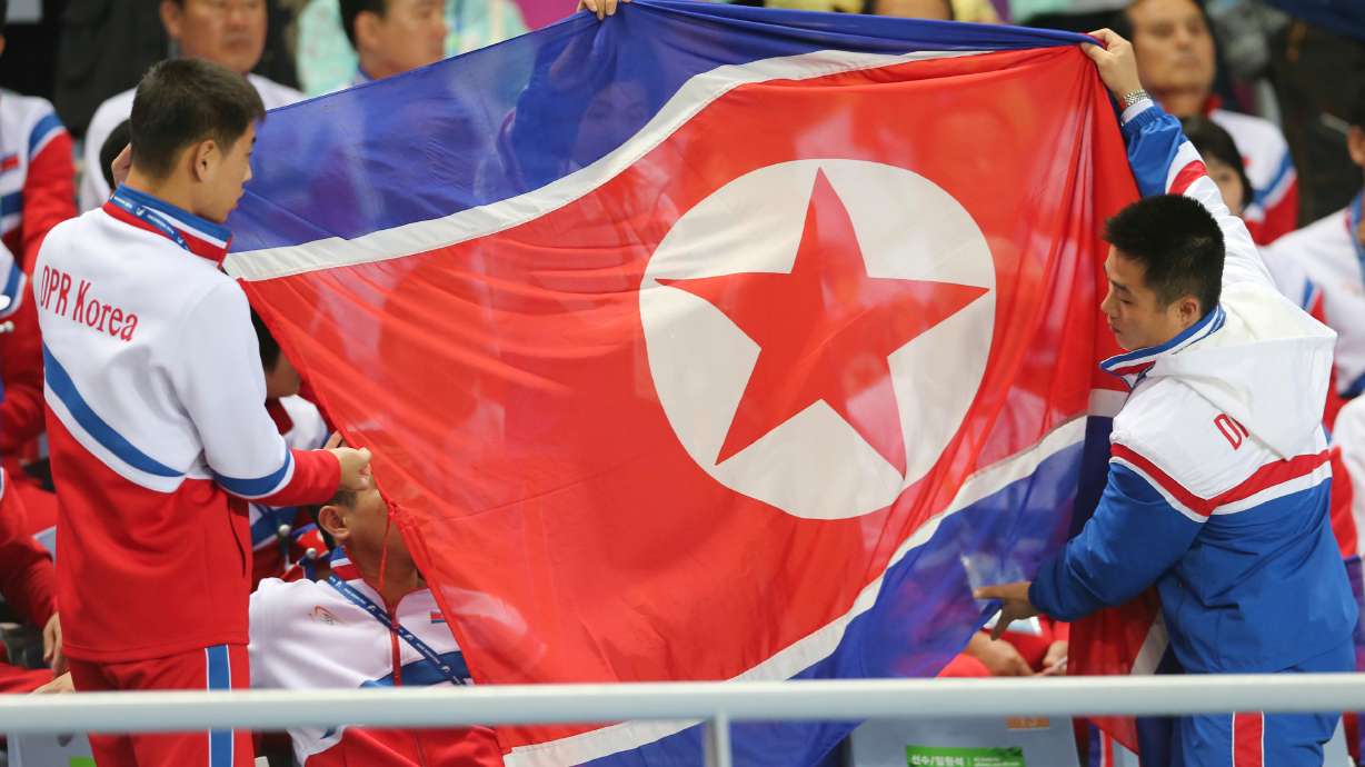 FILE - North Korea's delegation members prepare to spread the North Korean flag during their women's soccer final match at the 17th Asian Games in Incheon, South Korea, Oct. 1, 2014.