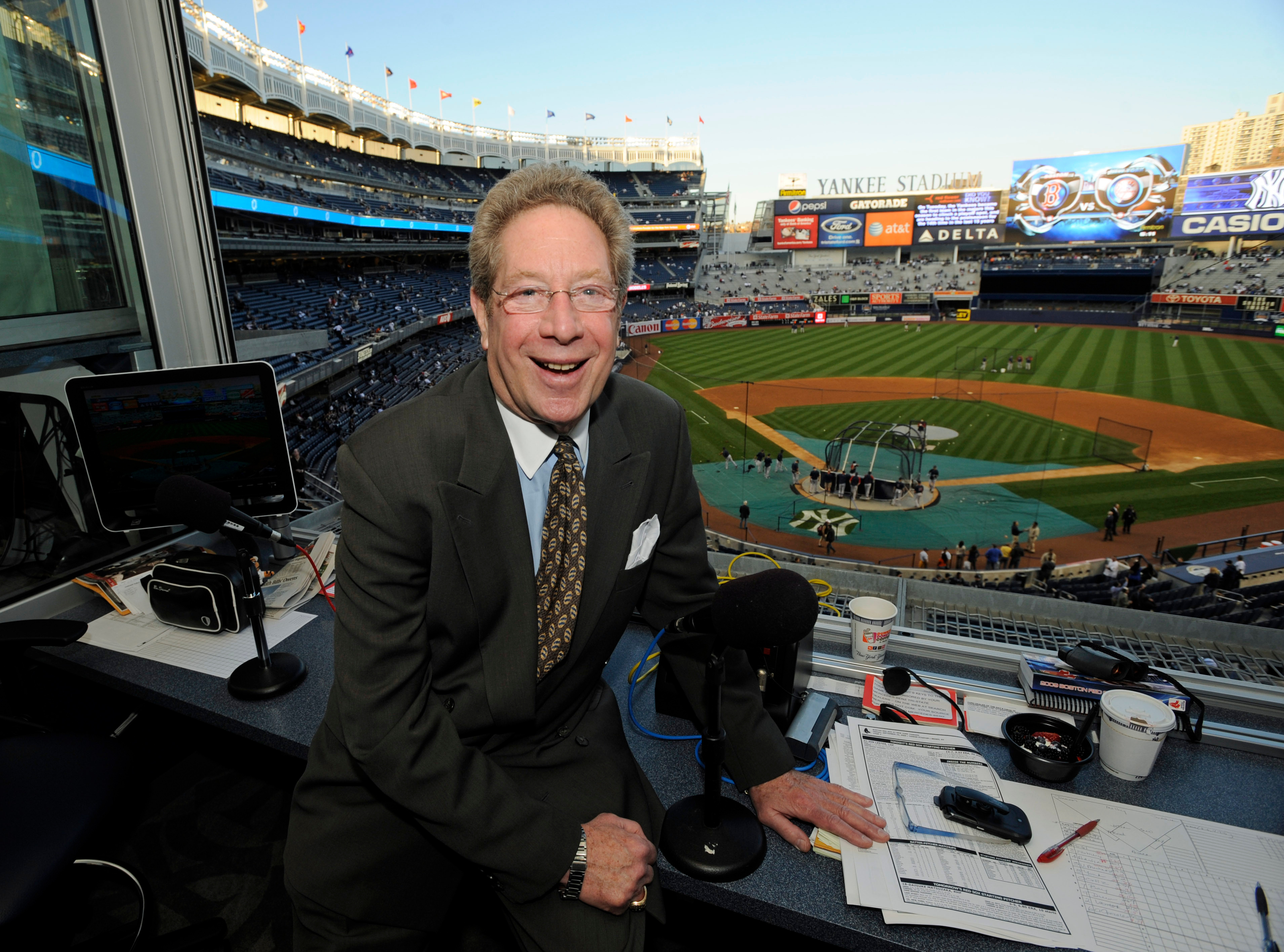 FILE - In this Sept. 25, 2009 file photo shows New York Yankees broadcaster John Sterling sitting in his booth before a baseball game against the Boston Red Sox at Yankee Stadium in New York.