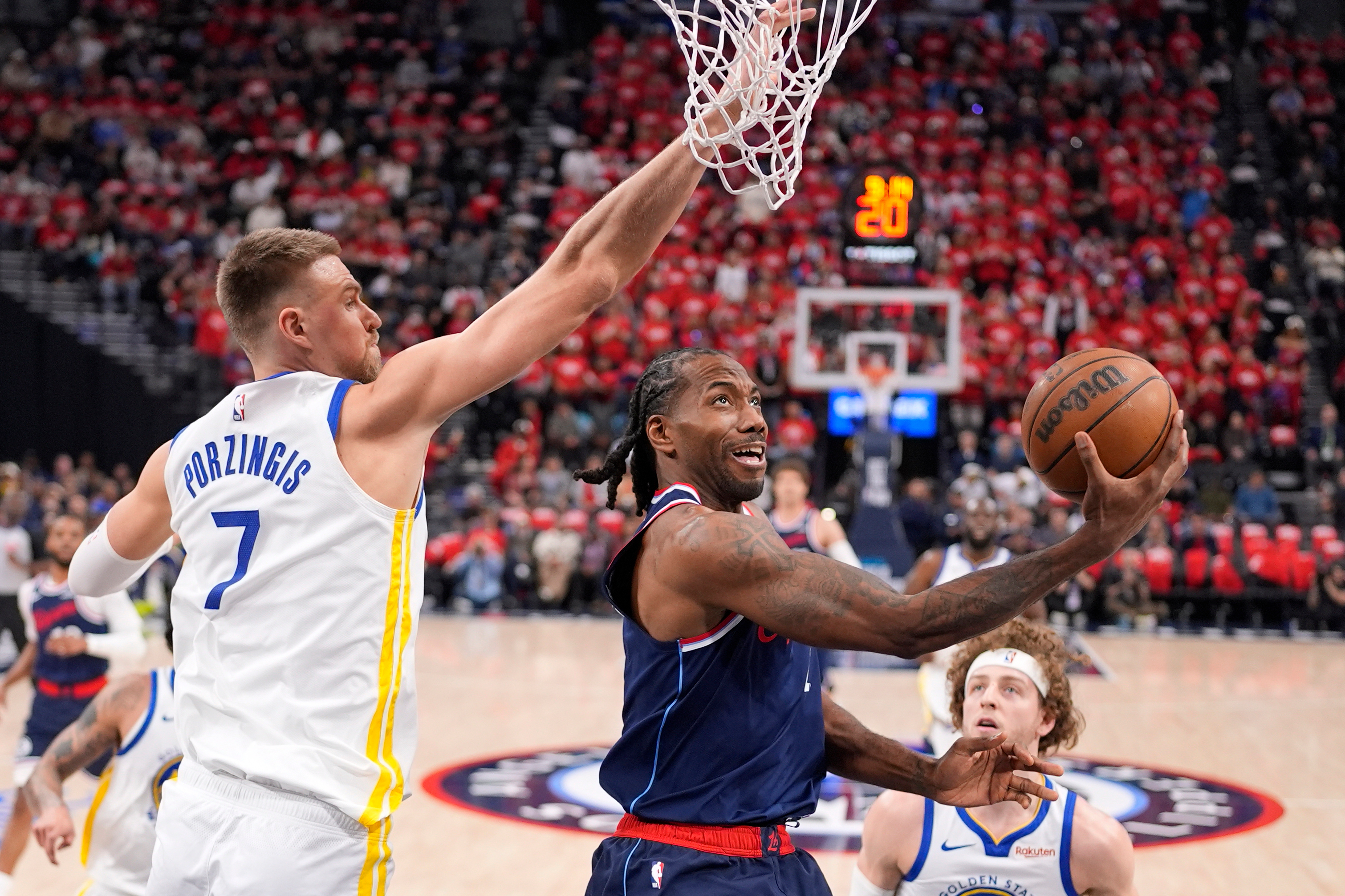 LA Clippers forward Kawhi Leonard, center, shoots as Golden State Warriors center Kristaps Porzingis defends during the first half of an NBA play-in tournament basketball game Wednesday, April 15, 2026, in Inglewood, Calif. 