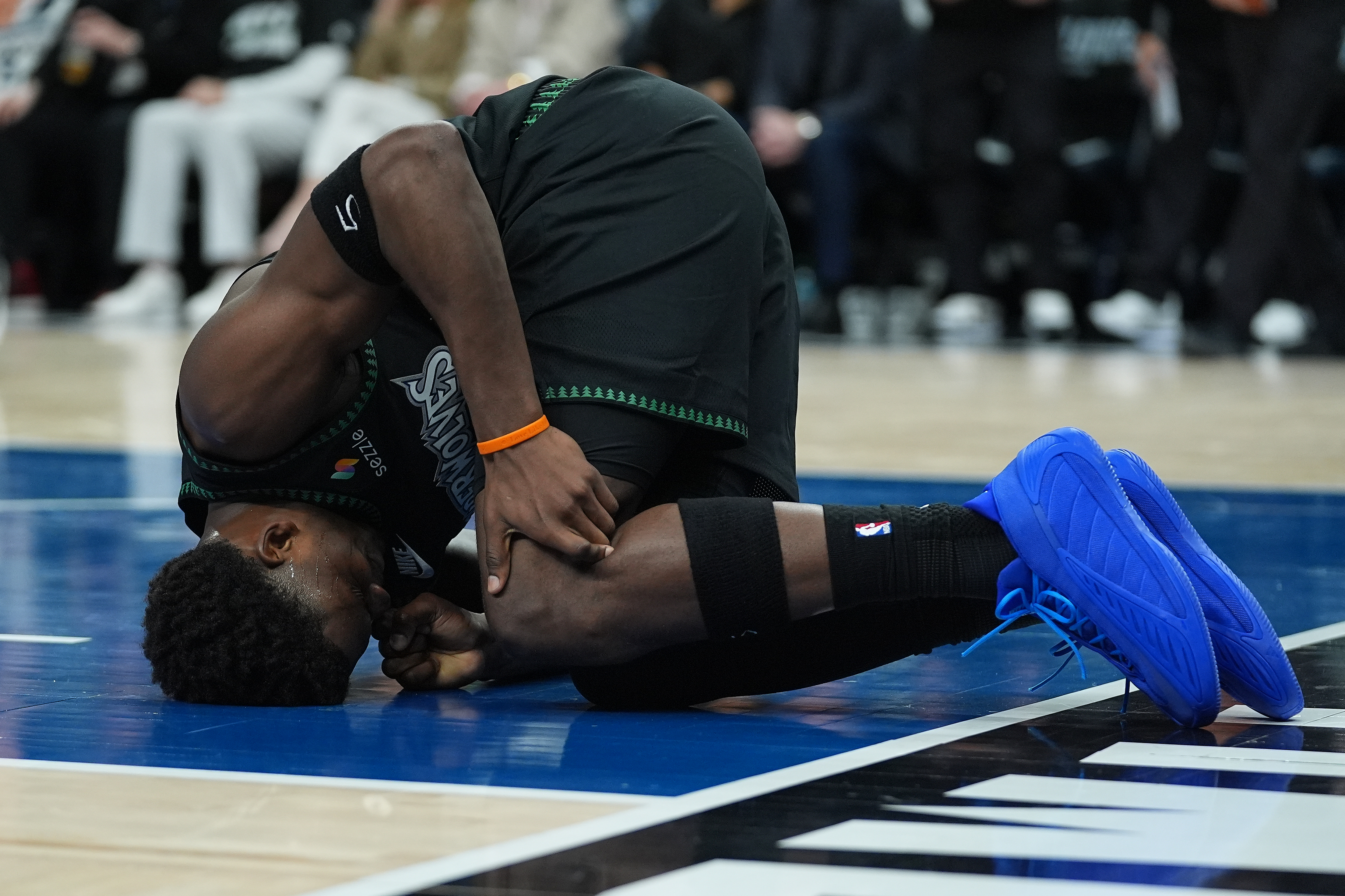 Minnesota Timberwolves guard Anthony Edwards kneels on the court after sustaining an injury during the first half of Game 4 of a first-round NBA basketball playoff series against the Denver Nuggets, Saturday, April 25, 2026, in Minneapolis.