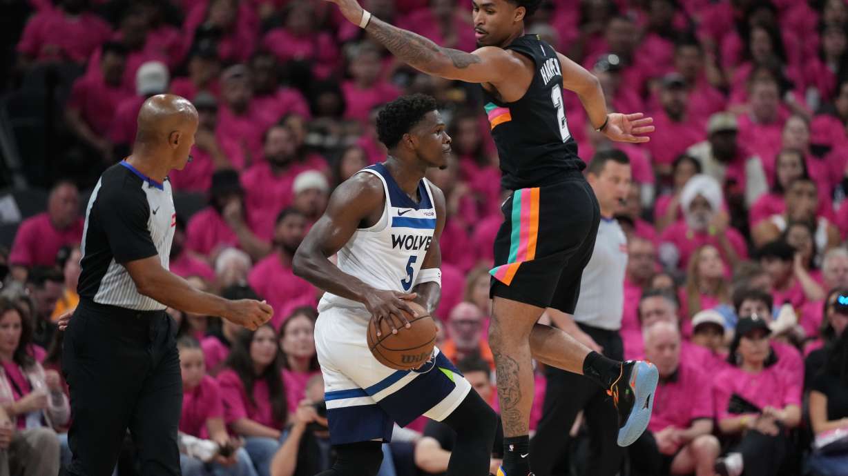 Minnesota Timberwolves guard Anthony Edwards (5) handles the ball as San Antonio Spurs guard Dylan Harper (2) defends during the first half in Game 1 of a second-round NBA playoffs basketball series in San Antonio, Monday, May 4, 2026.