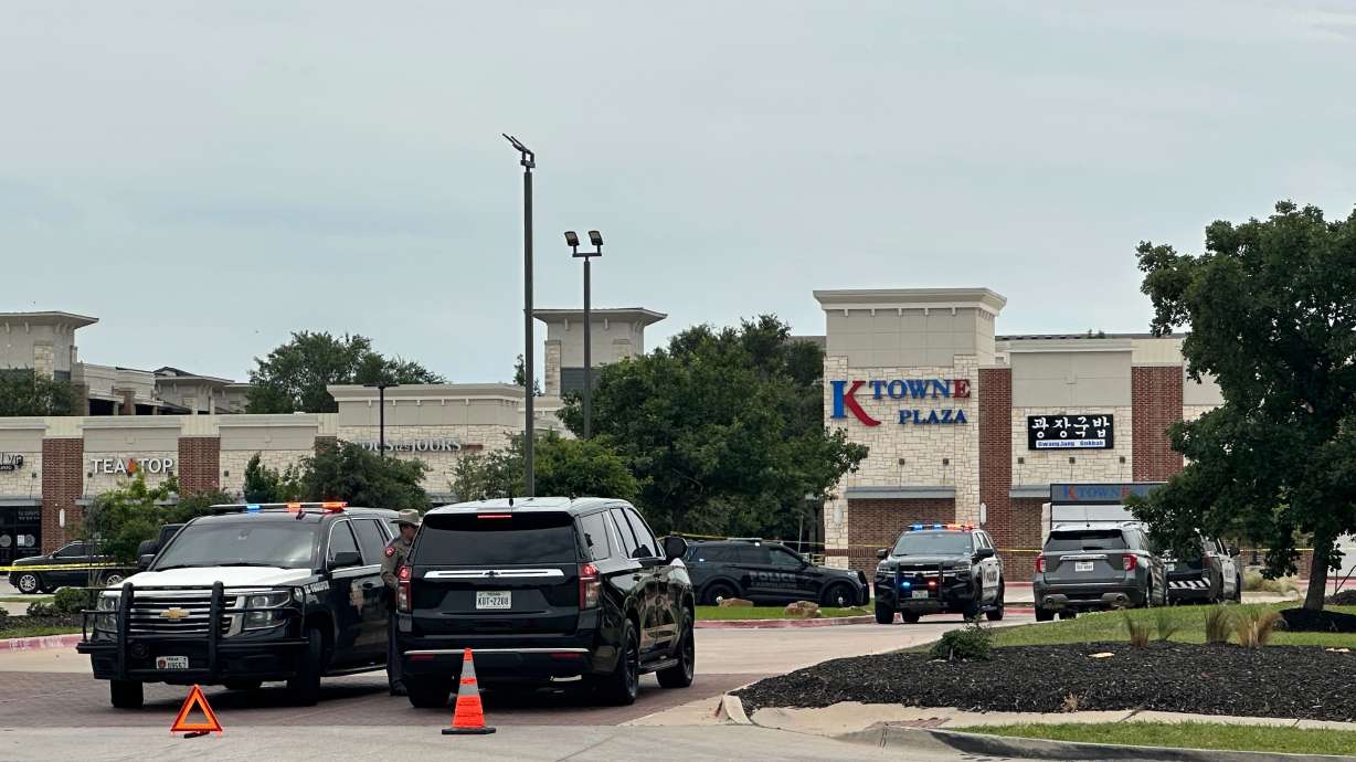 Law enforcement responds to the scene of a shooting Tuesday, at K Towne Plaza in Carrollton, Texas. Two people were killed and three more were injured in the shooting.