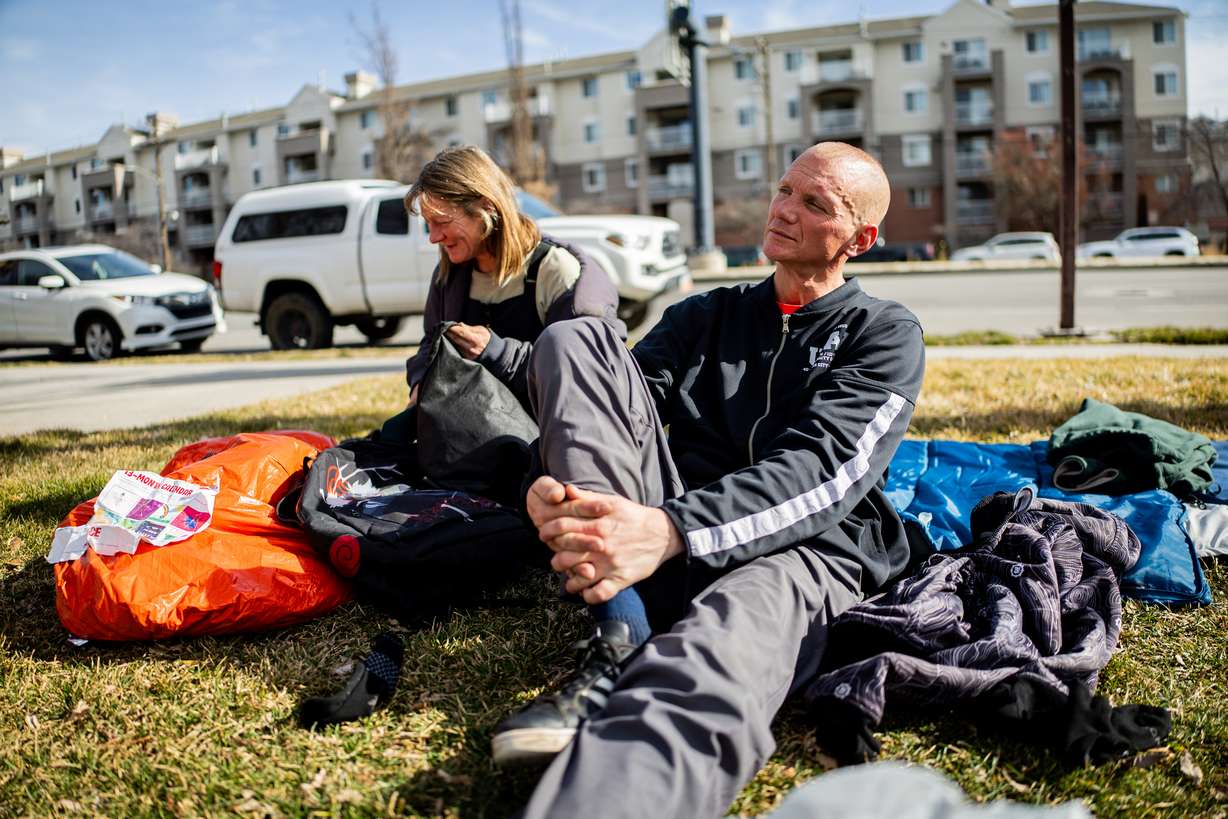 Ashley Miller, left, and Edwin Mangum, right, people experiencing homelessness, sit at Pioneer Park in Salt Lake City on Feb. 3.