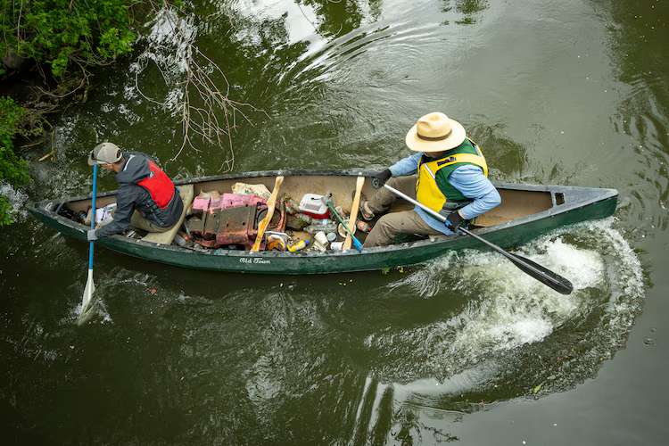 Sam Taylor and Carl Adams pick up trash along the banks of the Jordan River on April 22, 2026, as the Jordan River Commission hosted an Earth Day cleanup.