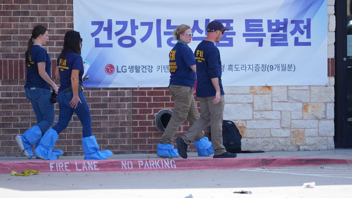 Officials respond to the scene of a shooting Tuesday, at K Towne Plaza in Carrollton, Texas. Police said the suspect was angry over business dealings with the victims.