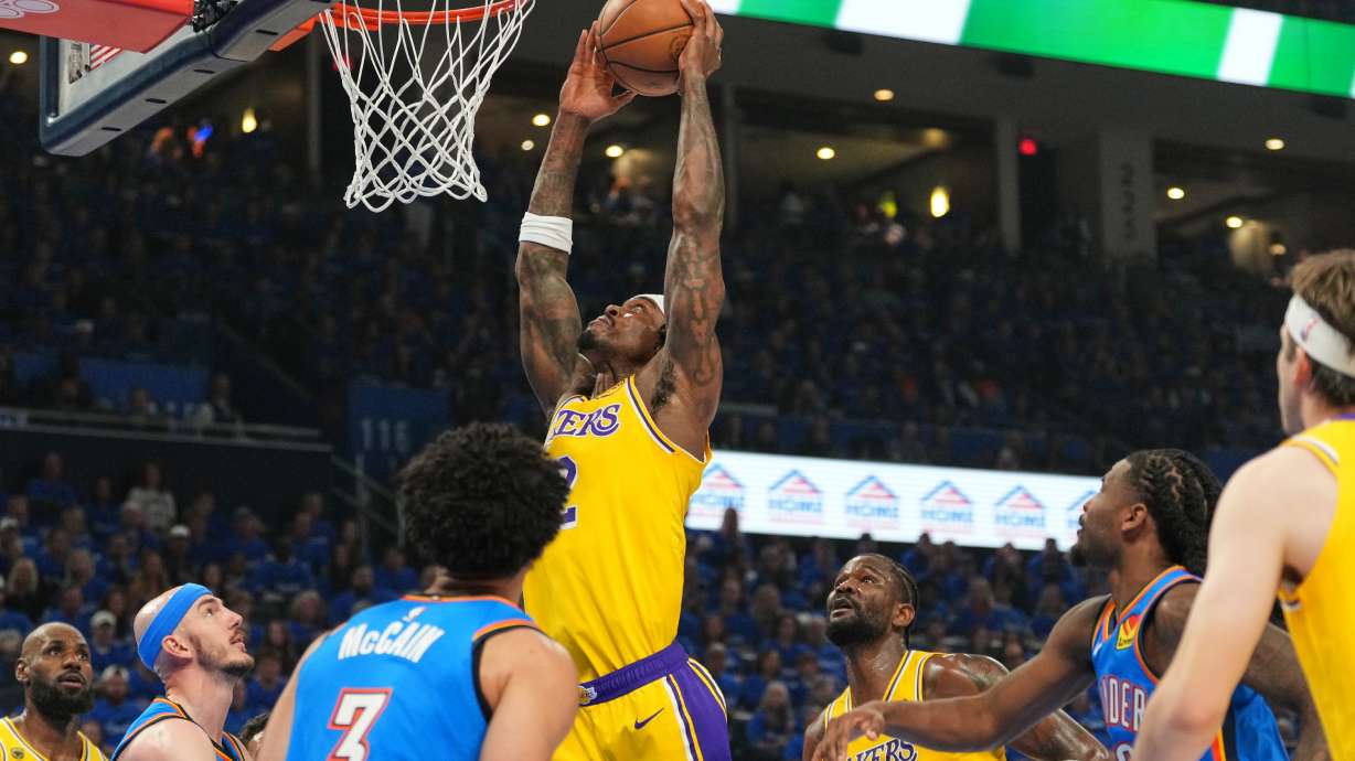Los Angeles Lakers forward Jarred Vanderbilt, center, goes up for a shot as Oklahoma City Thunder's Jared McCain (3) and Alex Caruso, second from left, defend in the first half of Game 1 in a second-round NBA basketball playoffs series Tuesday, May 5, 2026 in Oklahoma City.