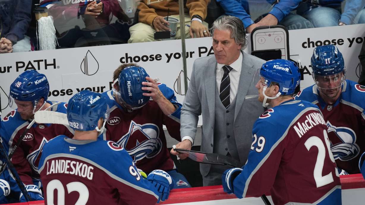 Colorado Avalanche head coach Jared Bednar, back right, confers with center Nathan MacKinnon, front right, and left wing Gabriel Landeskog in the third period of Game 2 of an NHL hockey Stanley Cup second-round playoff series against the Minnesota Wild Tuesday, May 5, 2026, in Denver.