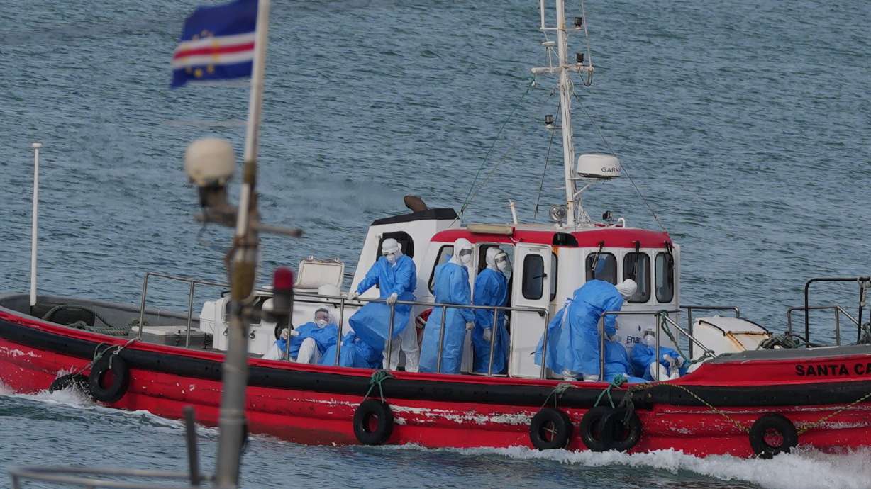 Health workers in protective gear arrive to evacuate patients from the MV Hondius cruise ship at a port in Praia, Cape Verde, Wednesday. Three passengers were evacuated off the ship, which is now sailing for the Canary Islands.