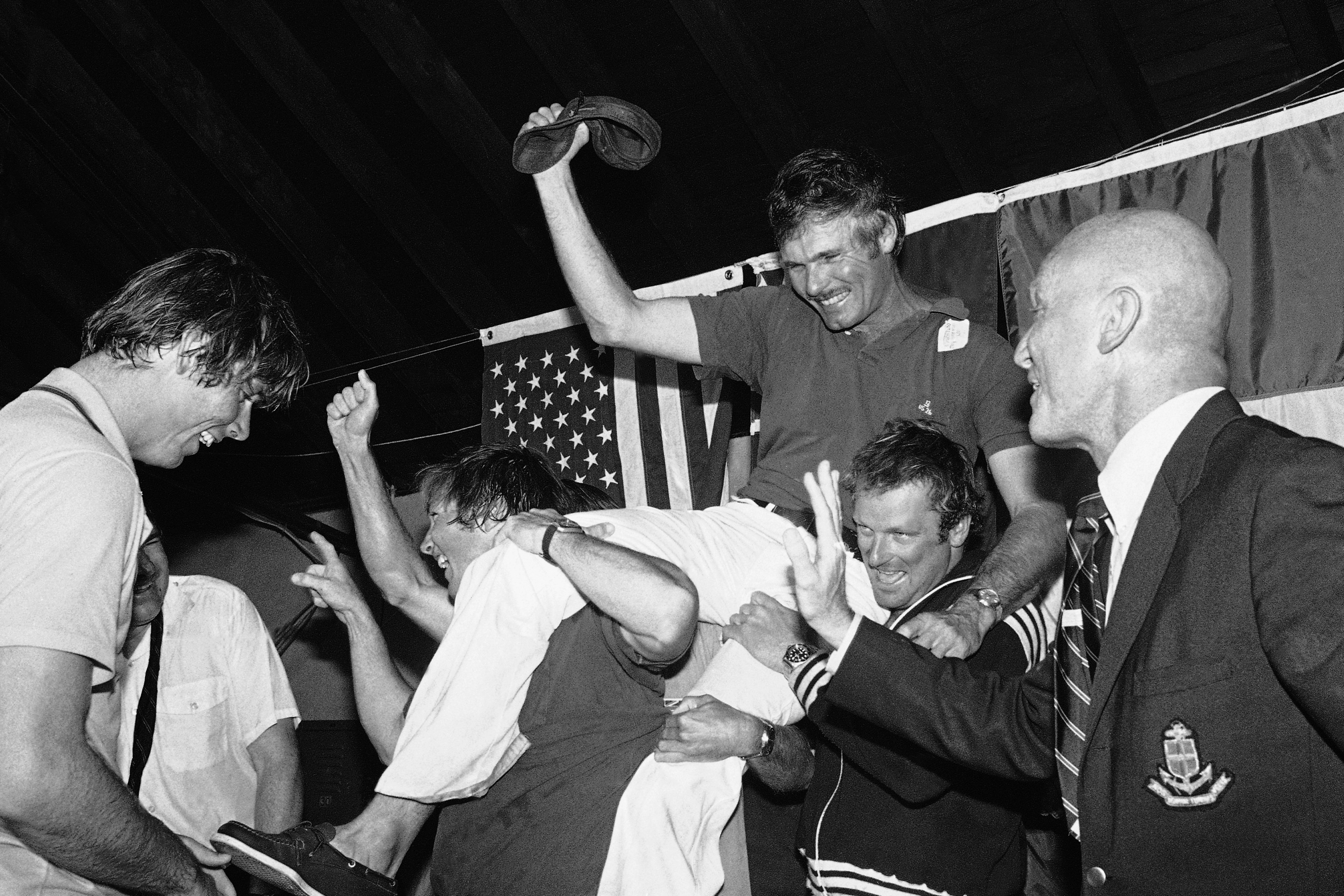 FILE - Ted Turner, center, is carried off by his crew following a news conference after his vessel Courageous won the Americas Cup sailing race, Sept. 19, 1977, in Newport, R.I. At right is Bill Ficker, skipper of cup winner Intrepid in 1970. 