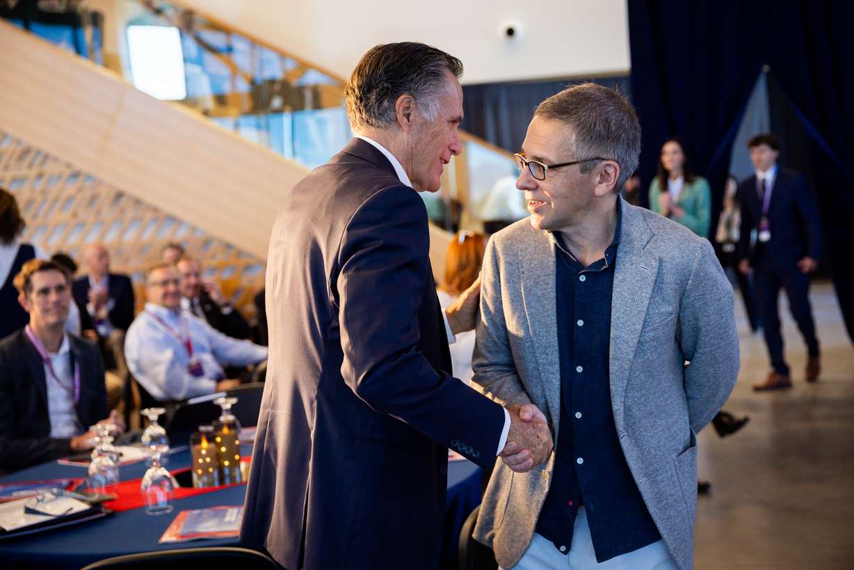 Mitt Romney, businessman and former U.S. senator, shakes hands with Ian Bremmer, president and founder of Eurasia Group and GZERO Media, after Bremmer spoke during the Crossroads of the World International Trade Summit at Zions Bancorporation’s Midvale Technology Center on Wednesday. Romney introduced Bremmer before Bremmer spoke.