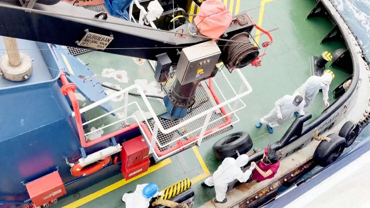 Health workers get off the Dutch-flagged MV Hondius, a cruise ship carrying nearly 150 people, as it remains off Cape Verde on Monday, after three passengers died and several others fell seriously ill in a suspected hantavirus outbreak.