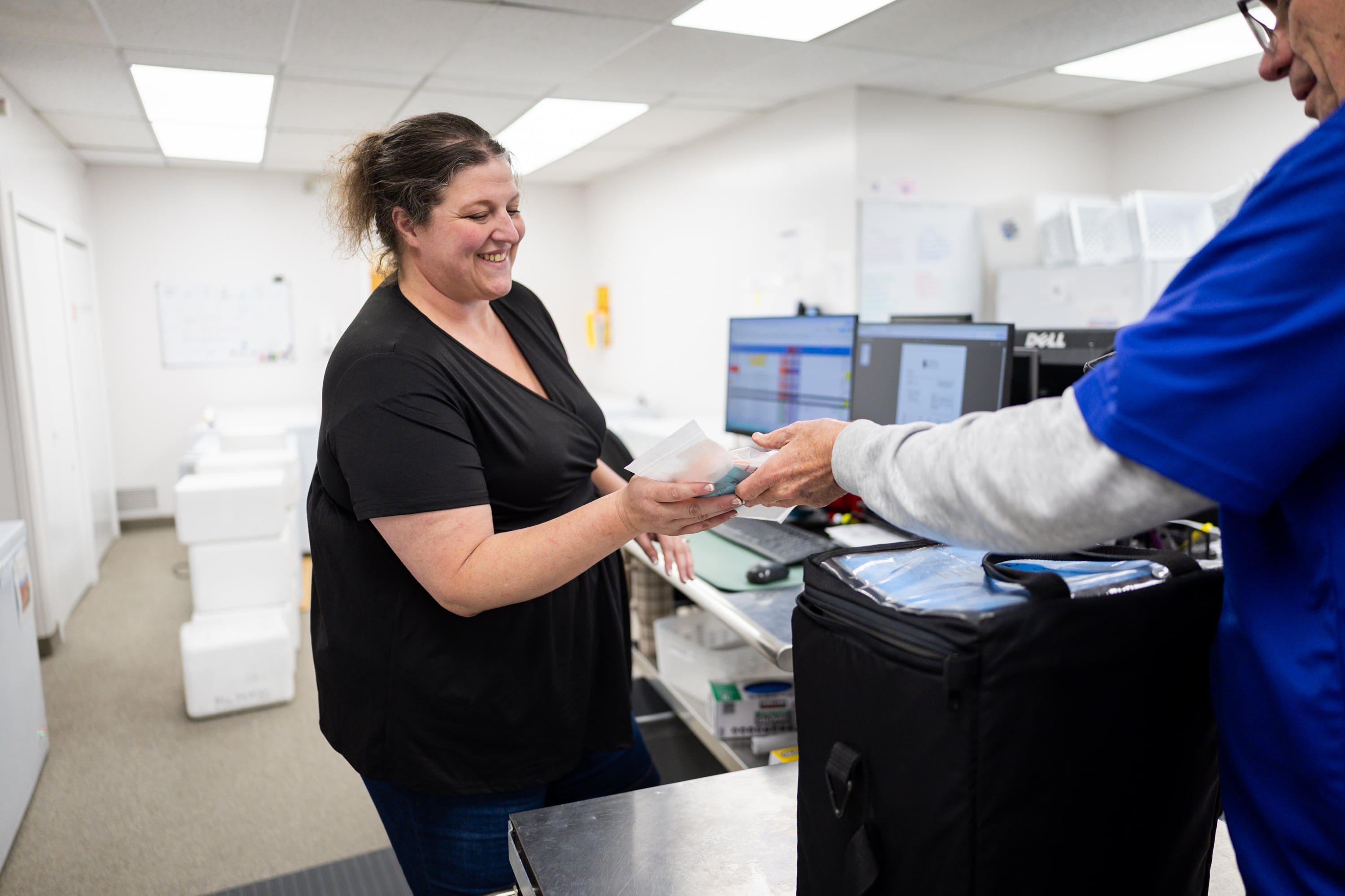 Trista Jackson, shipping and receiving lead at the Mountain West Mothers' Milk Bank, left, receives milk from one of their partner hospitals from Steve Sawn, courier for Intermountain Health, at the Mountain West Mothers' Milk Bank in South Salt Lake on Tuesday.
