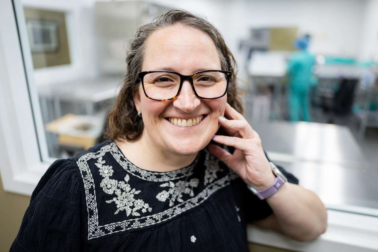 Amanda Ottley, executive director at the Mountain West Mothers' Milk Bank, poses at the Mountain West Mothers' Milk Bank in South Salt Lake while Allison Spencer, lab lead, and Vanessa Almaraz, lab technician, pasteurize milk in the background on Tuesday.