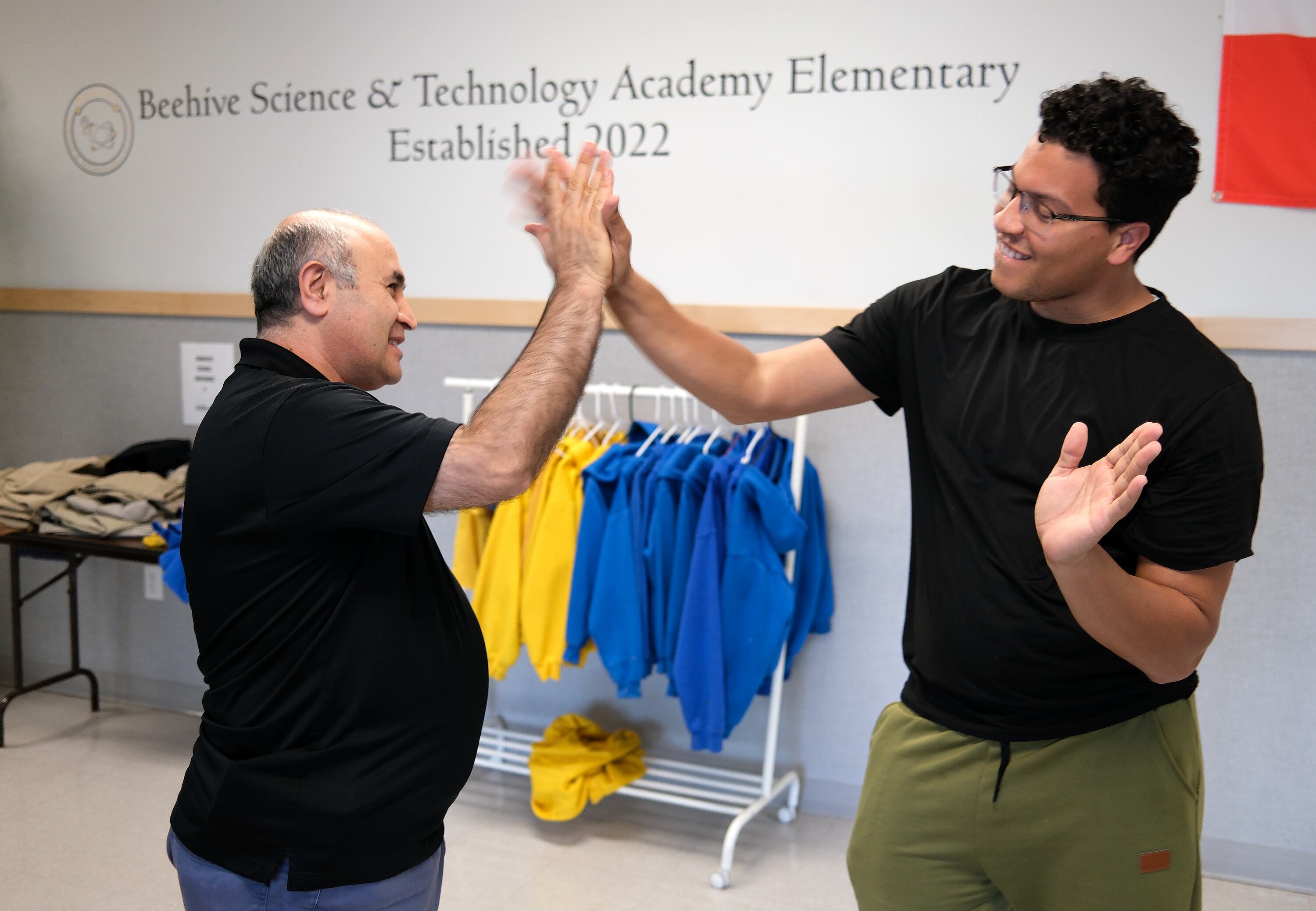 Hanifi Oguz, Beehive Science and Technology Academy executive director, high-fives Matt McKinney, third grade teacher, as Oguz walks around Beehive Science and Technology Academy after school in Sandy on Thursday. The school includes elementary, middle and high school.