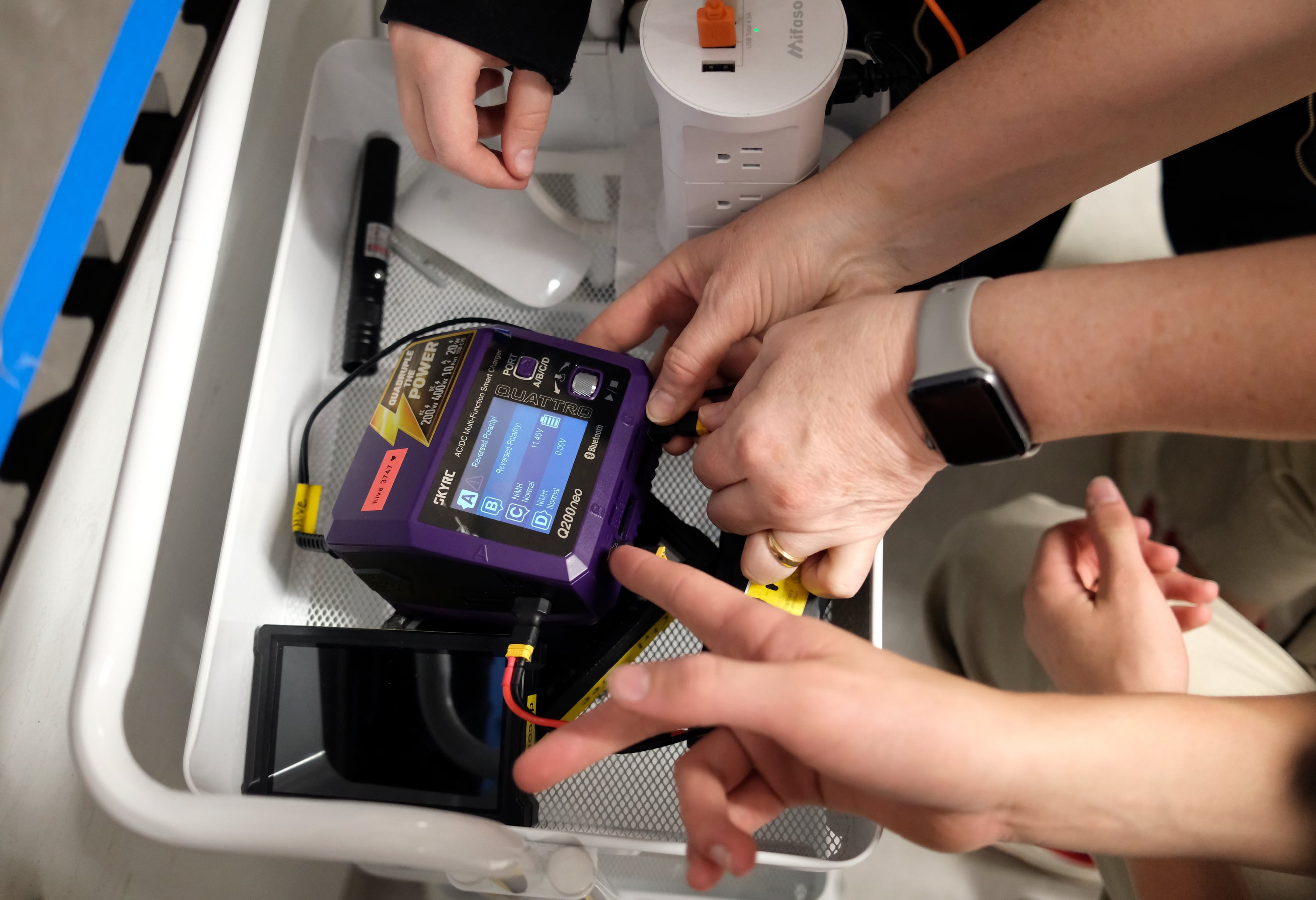 Samuel Horvitz, high school freshman, and Dakota Drennan, high school junior, and their robotics coach Annie Drennan set up robot batteries for recharging after practicing for the FIRST Tech Challenge robotics competition at Beehive Science and Technology Academy in Sandy on Thursday.