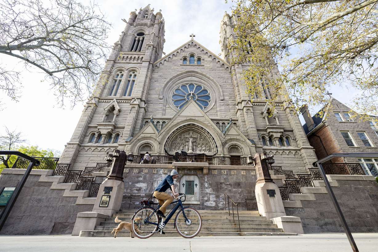 A cyclist rides past the Cathedral of the Madeleine in Salt Lake City on April 22, 2025. The Madeleine School Choir is performing "Noah's Flood" at the cathedral this weekend.