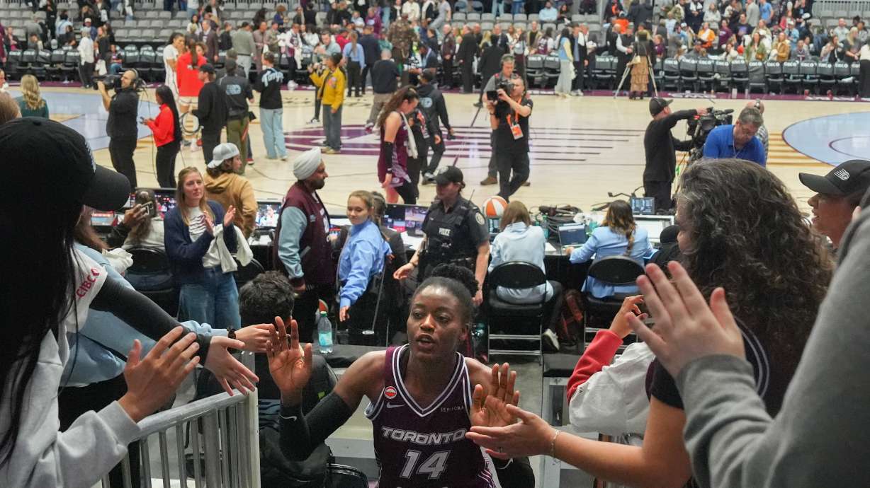 Toronto Tempo's Temi Fagbenle (14) high-fives fans as she comes off the court after her team's first WNBA basketball game, aganst the Washington Mystics, in Toronto, Friday, May 8, 2026.