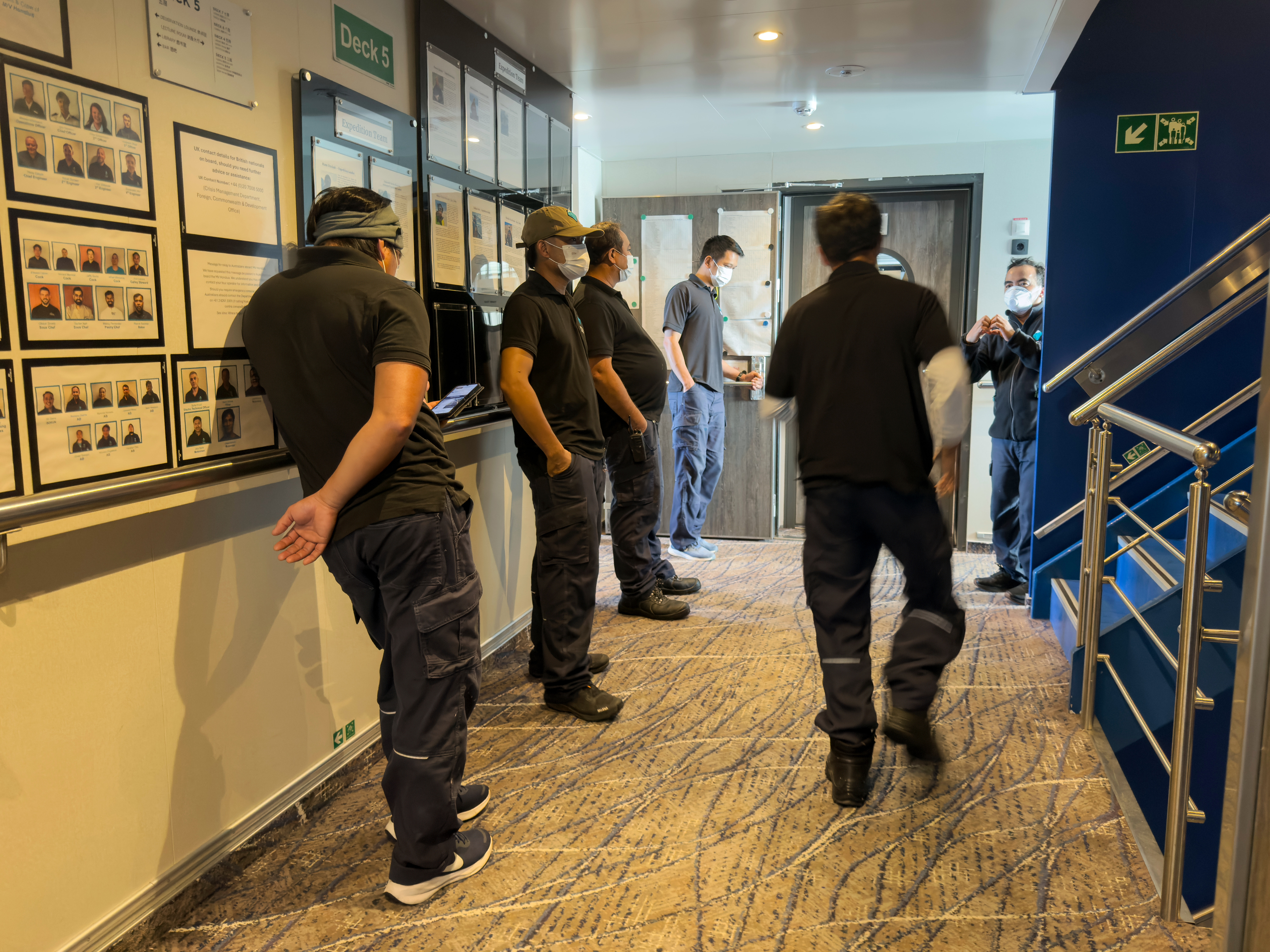 Crew members of the hantavirus-stricken cruise ship, MV Hondius, wait their turns for a first interview with epidemiologists, during the voyage to Spain's port of Tenerife, Wednesday. The ship is expected to arrive in Tenerife on Sunday.
