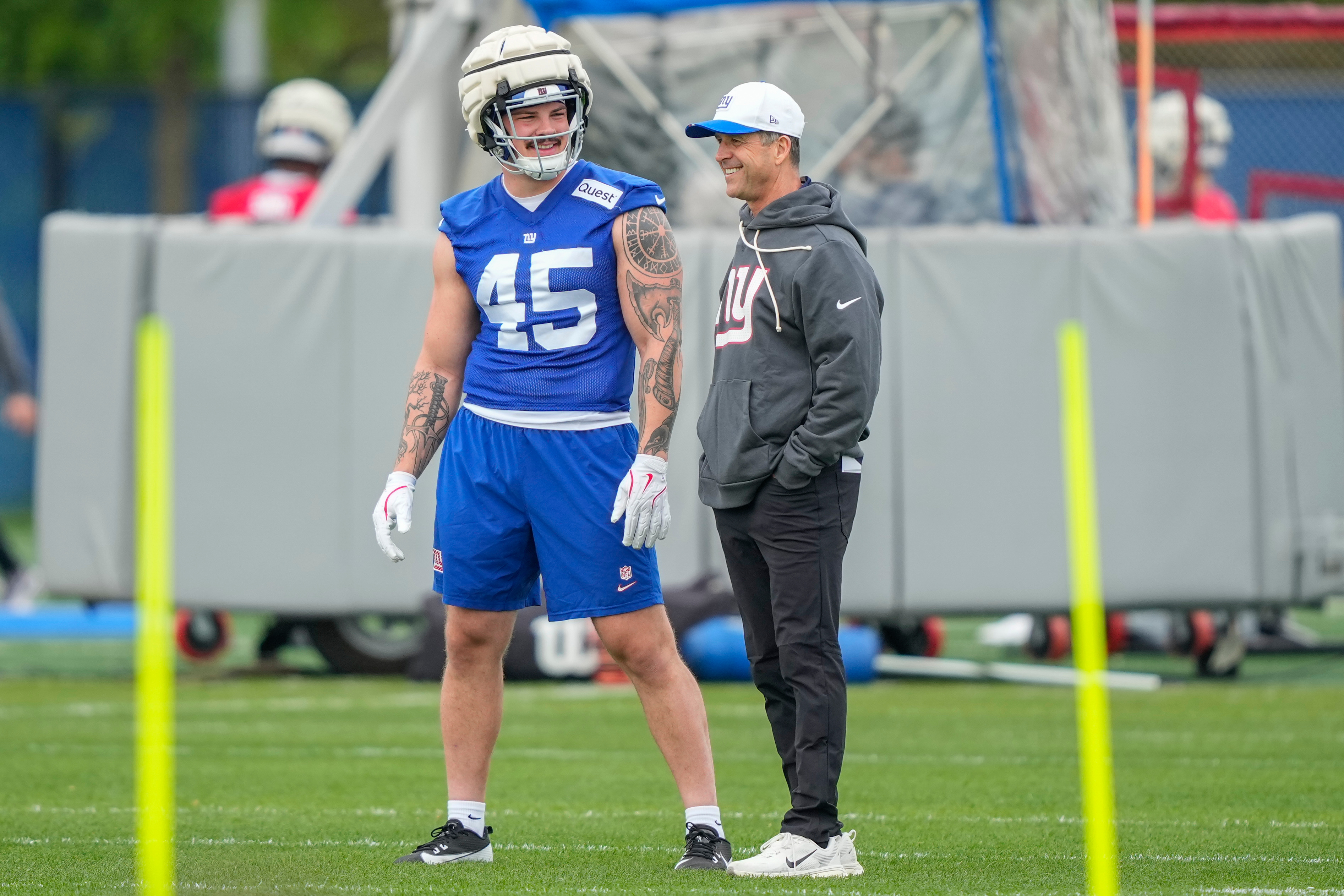 New York Giants head coach John Harbaugh, right, talks with New York Giants fullback Grant Finley, left, (45) at rookie minicamp at the NFL football team's practice facility, Saturday, May 9, 2026, in East Rutherford, N.J. 