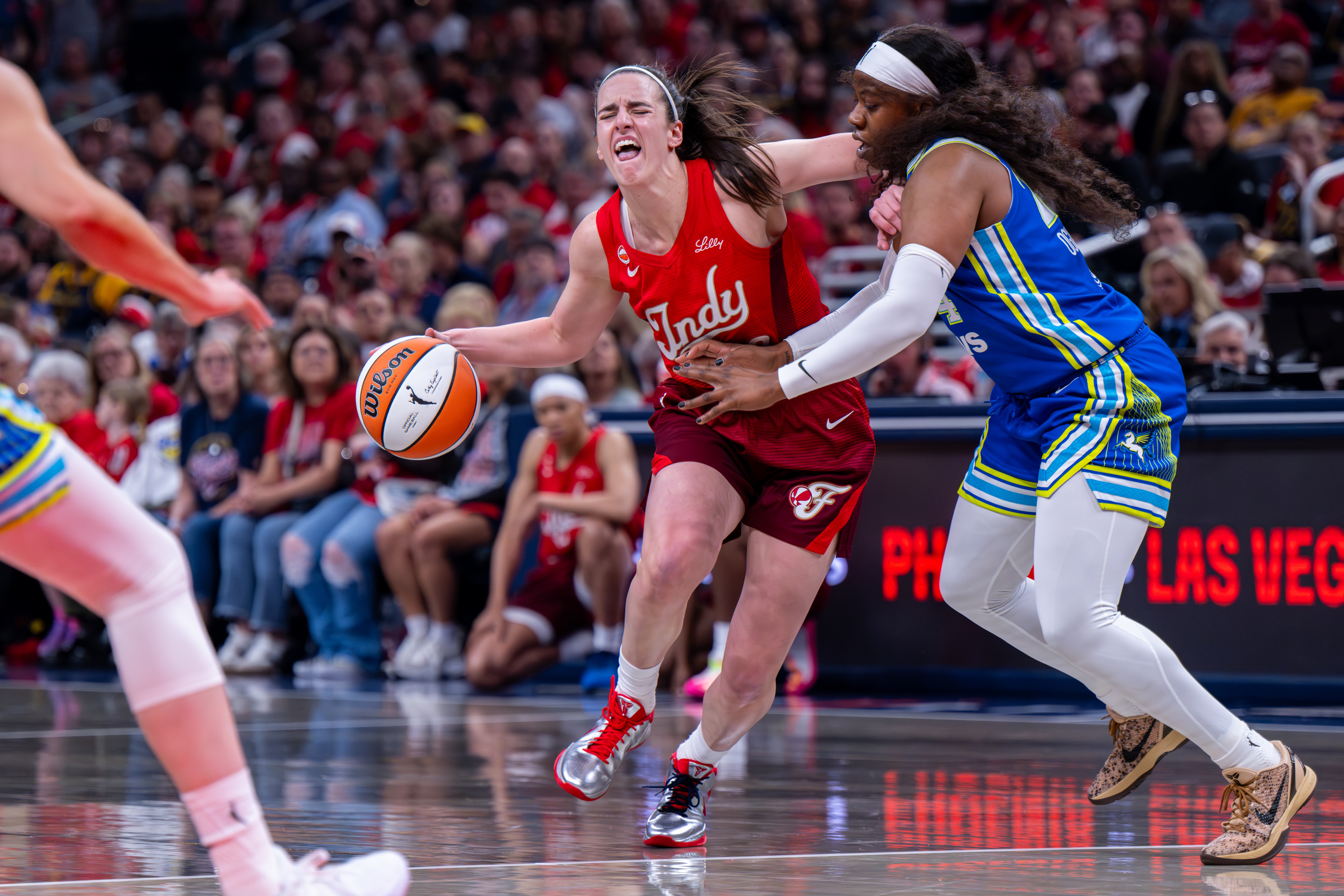 Indiana Fever guard Caitlin Clark (22) reacts as she makes contact with the defense of Dallas Wings guard Arike Ogunbowale (24) during the first half of an WNBA basketball game in Indianapolis, Saturday, May 9, 2026. 