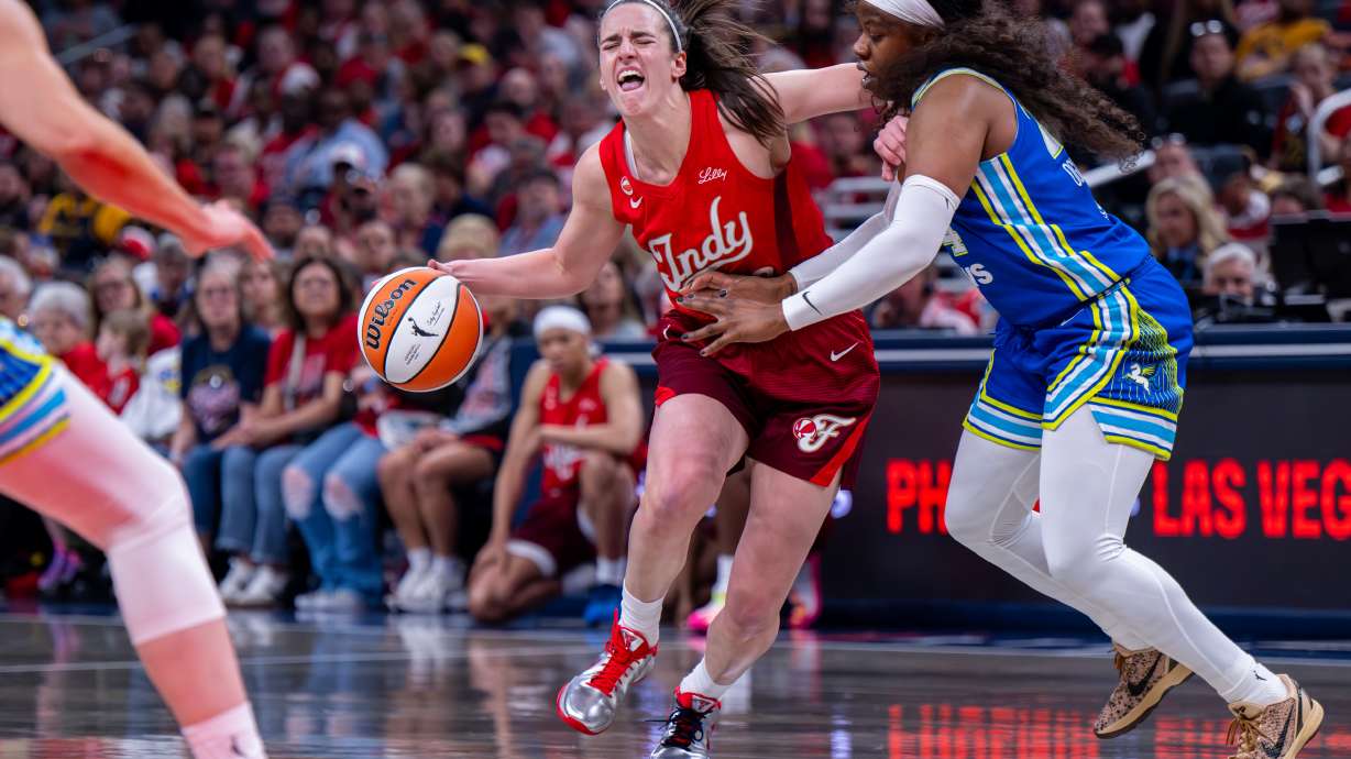 Indiana Fever guard Caitlin Clark (22) reacts as she makes contact with the defense of Dallas Wings guard Arike Ogunbowale (24) during the first half of an WNBA basketball game in Indianapolis, Saturday, May 9, 2026.