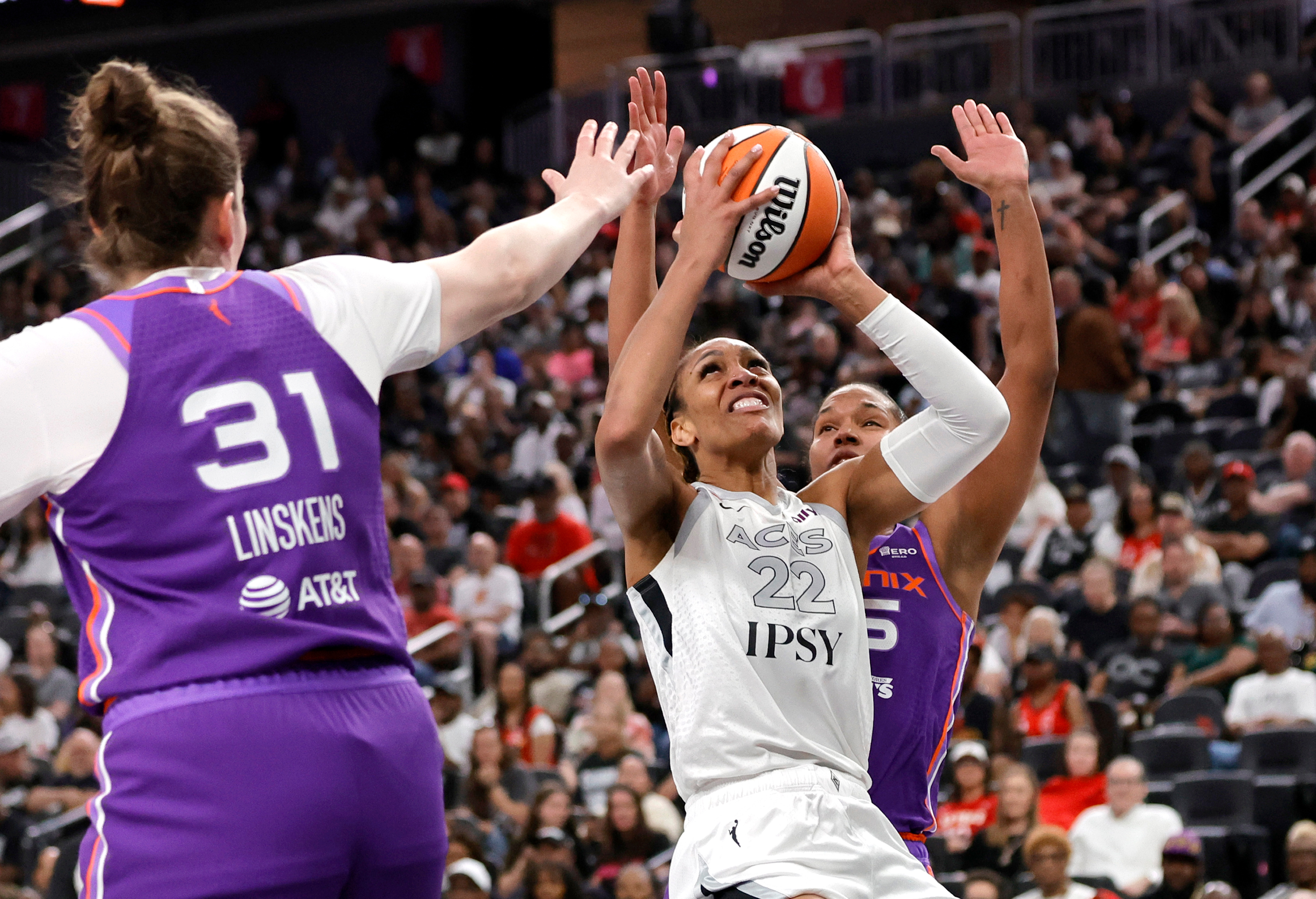 Las Vegas Aces center A'ja Wilson (22) looks to shoot between Phoenix Mercury center Kyara Linskens (31) and forward Alyssa Thomas, right, during the first half of an WNBA basketball game Saturday, May 9, 2026, in Las Vegas.