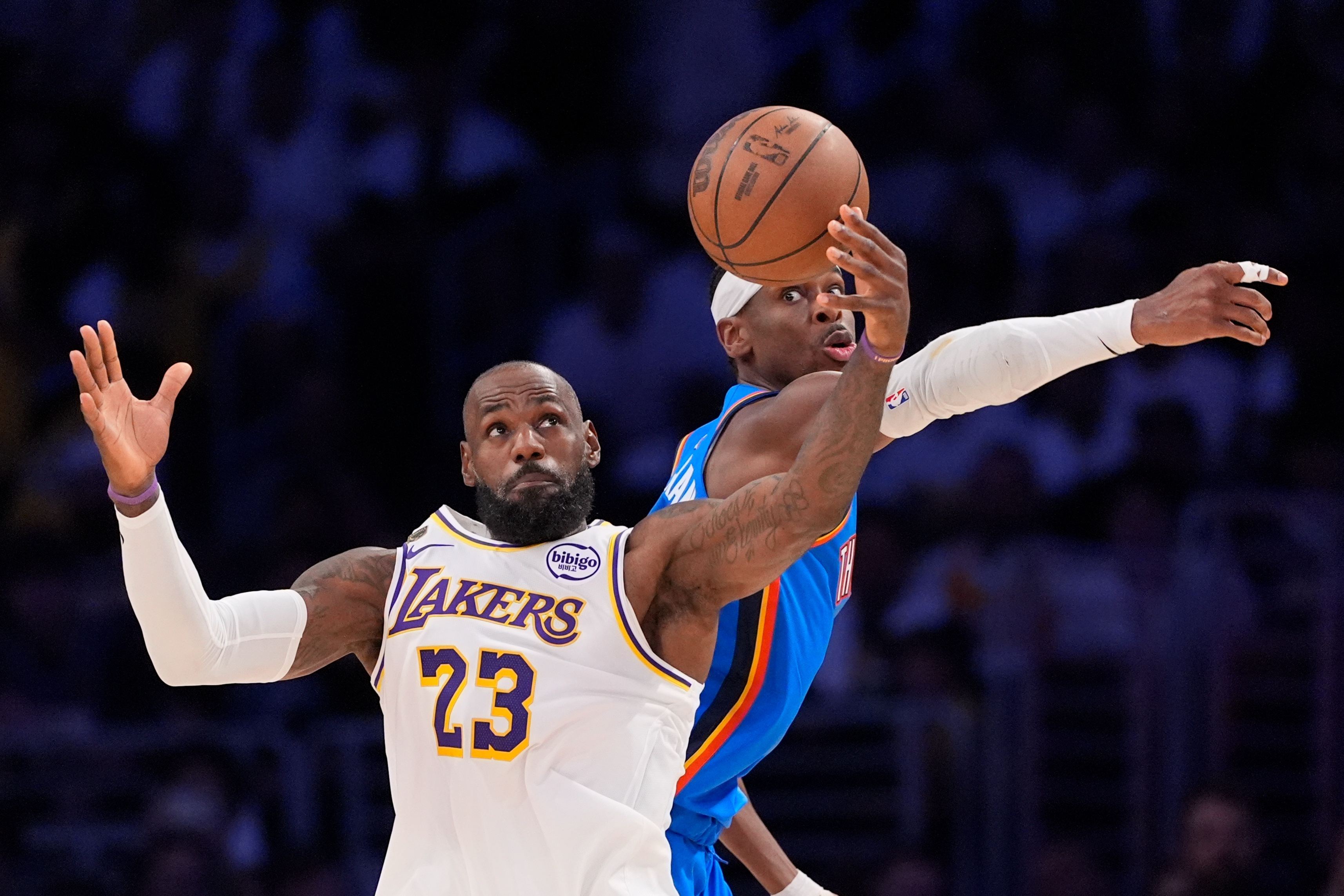Los Angeles Lakers forward LeBron James, left, takes a pass as Oklahoma City Thunder guard Shai Gilgeous-Alexander defends during the first half of Game 3 in a second-round NBA basketball playoffs series Saturday, May 9, 2026, in Los Angeles.