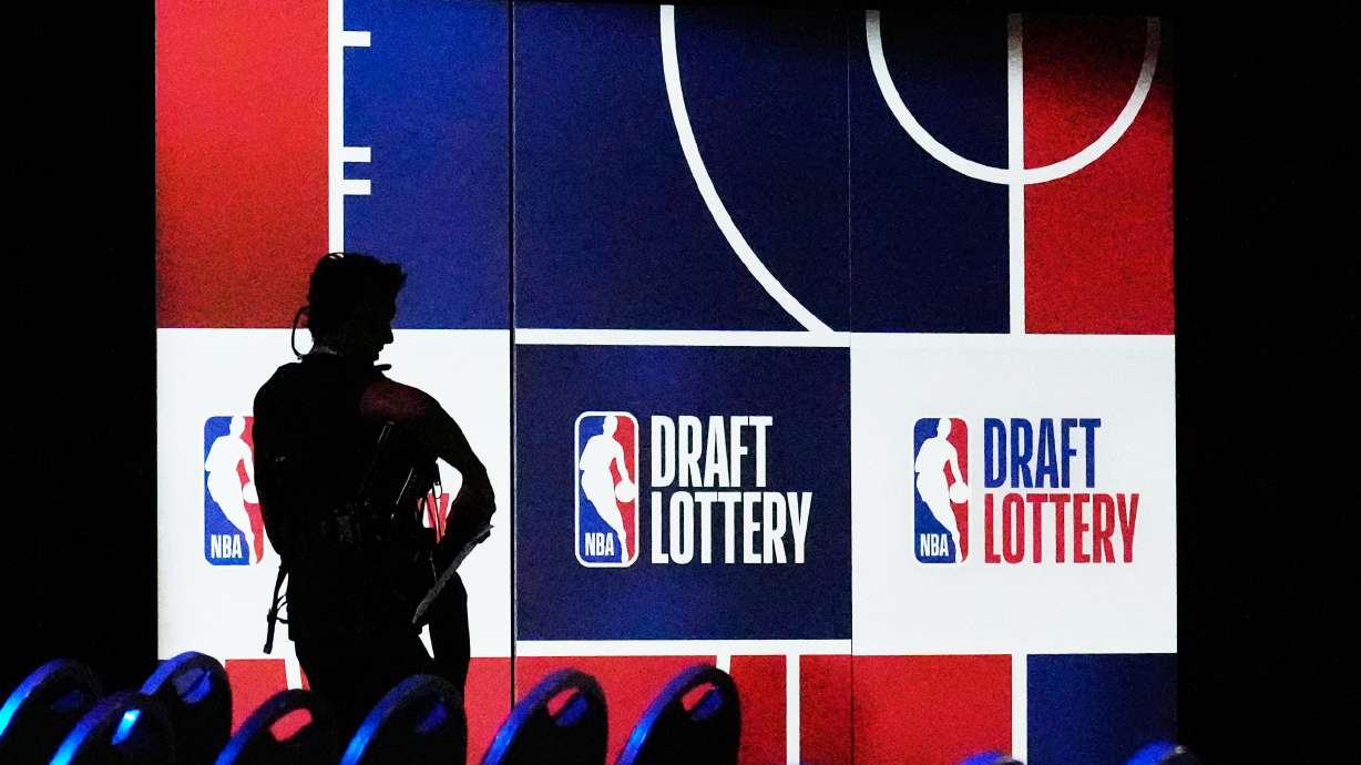 A person walks by a sign in the NBA basketball draft lottery in Chicago, Sunday, May 10, 2026.