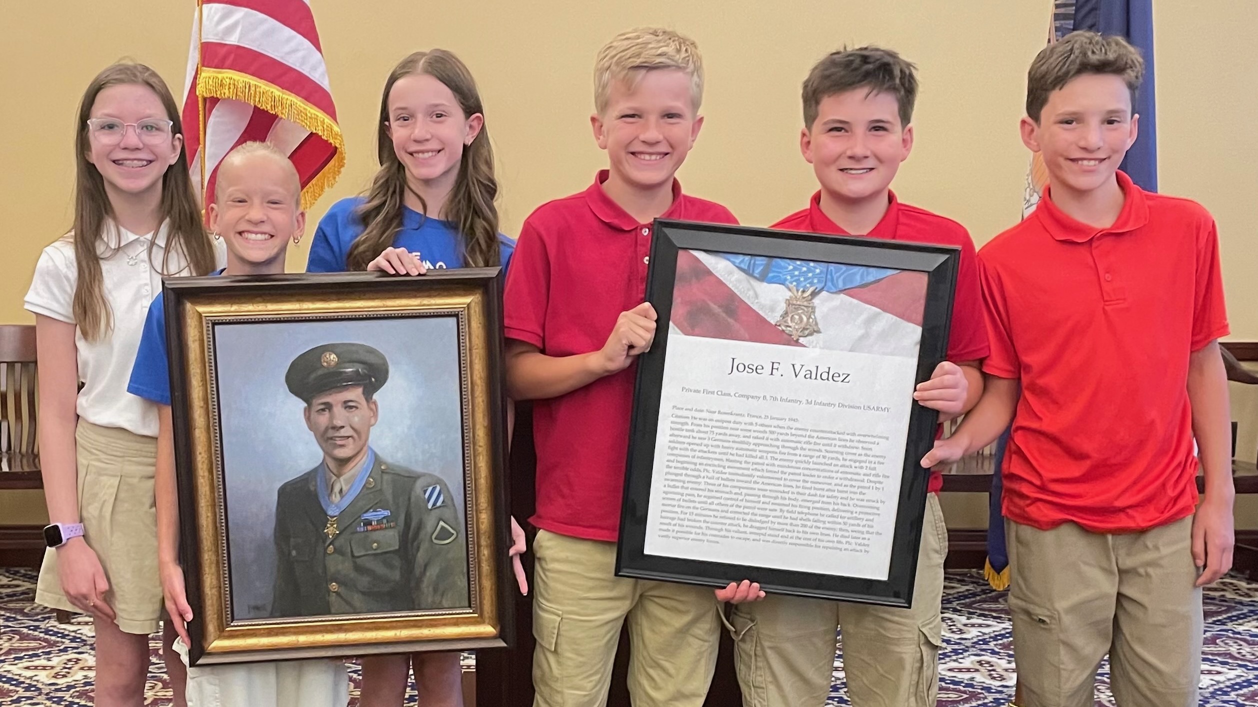 Boosters of Army Pfc. Jose Valdez, a Medal of Honor recipient, seek homes for seven prints of the man that remain. One print, shown here with students from Mountainville Academy during a ceremony Monday at the Capitol in Salt Lake City, will go to the Alpine school.