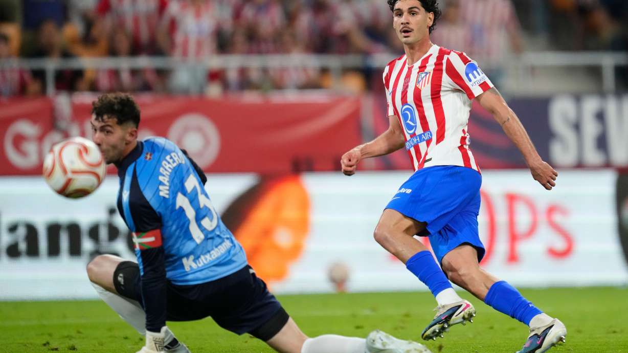 Atletico Madrid's Johnny Cardoso, right, shoots the ball past Real Sociedad's goalkeeper Unai Marrero during the Copa del Rey final soccer match between Atletico Madrid and Real Sociedad in Seville, Spain, Saturday, April. 18, 2026.