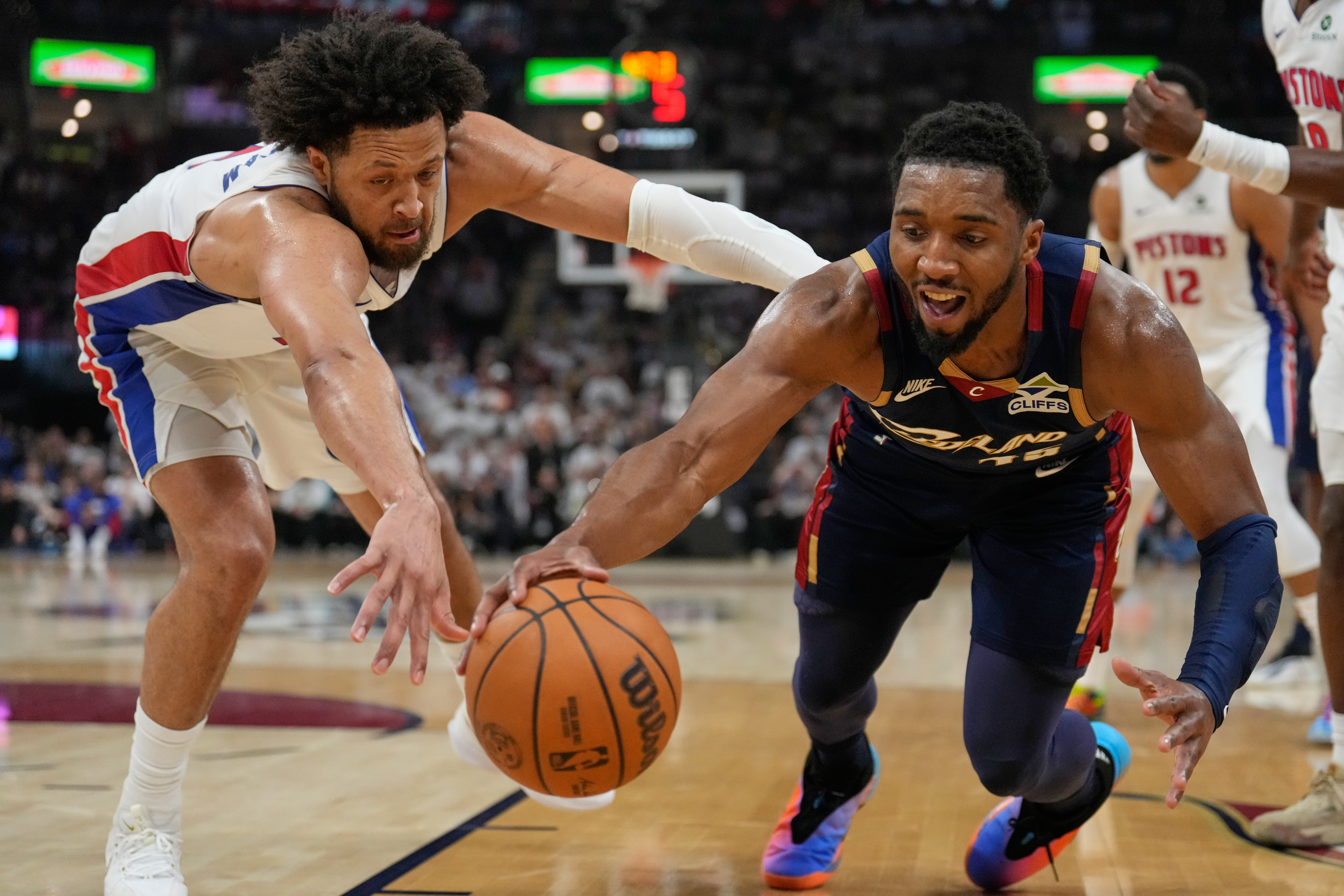 Detroit Pistons' Cade Cunningham, left, and Cleveland Cavaliers' Donovan Mitchell, right, reach for the ball in the first half of Game 4 of a second-round NBA basketball playoff series Monday, May 11, 2026, in Cleveland.