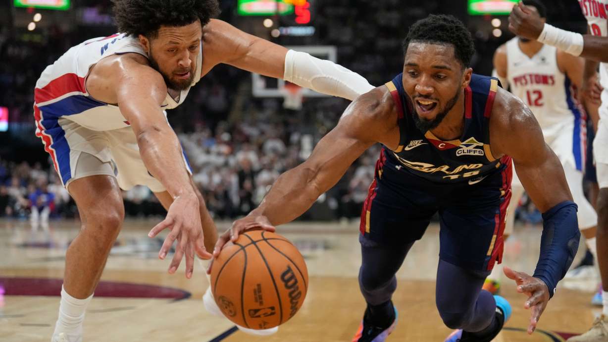 Detroit Pistons' Cade Cunningham, left, and Cleveland Cavaliers' Donovan Mitchell, right, reach for the ball in the first half of Game 4 of a second-round NBA basketball playoff series Monday, May 11, 2026, in Cleveland.
