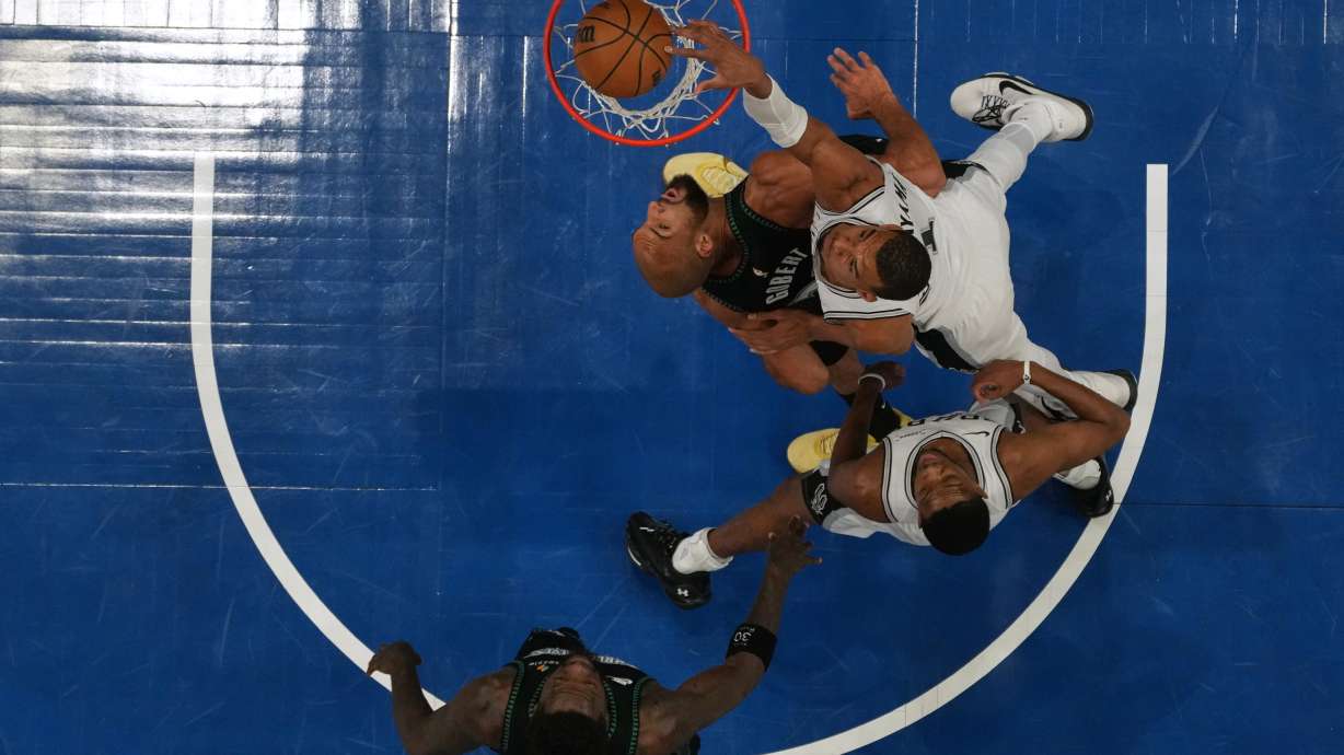 San Antonio Spurs forward Victor Wembanyama (1), right, scores against Minnesota Timberwolves center Rudy Gobert (27) during the first half of Game 4 of an NBA basketball second-round playoffs series, Sunday, May 10, 2026, in Minneapolis.
