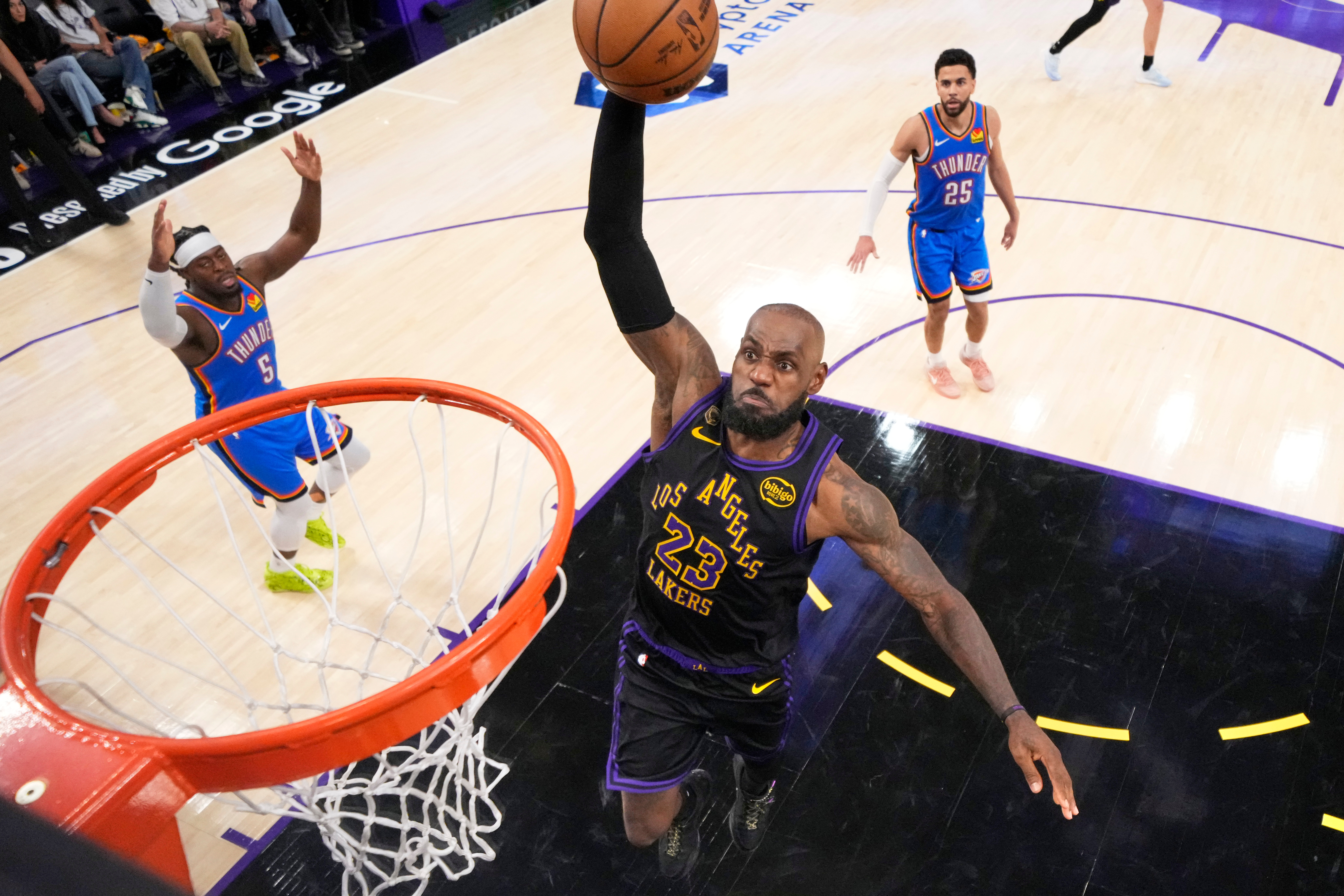 Los Angeles Lakers forward LeBron James, center, goes up for a dunk as Oklahoma City Thunder guard Luguentz Dort, left, and guard Ajay Mitchell watch during the second half of Game 4 in a second-round NBA basketball playoffs series Monday, May 11, 2026, in Los Angeles. 