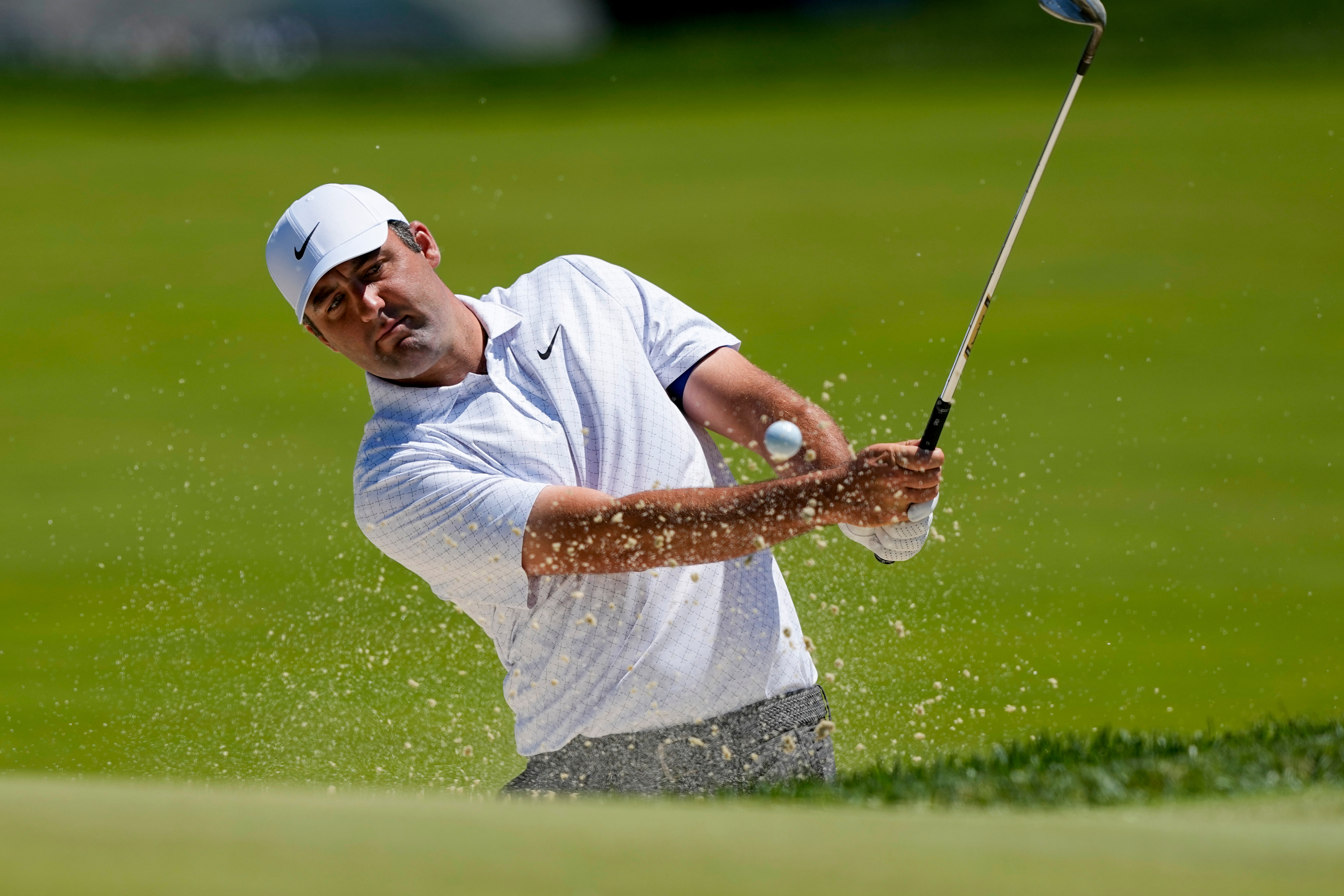 Scottie Scheffler hits from the bunker on the third green during a PGA Championship golf tournament practice round at Aronimink Golf Club, Tuesday, May 12, 2026, in Newtown Square, PA. 