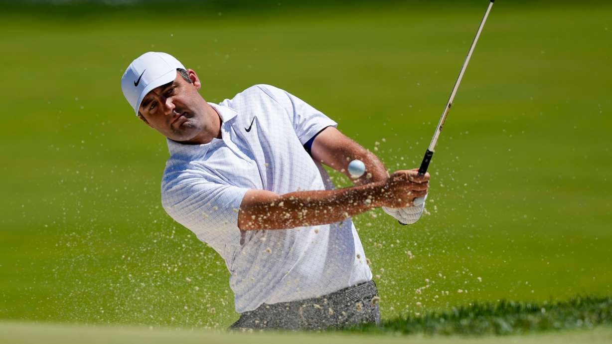 Scottie Scheffler hits from the bunker on the third green during a PGA Championship golf tournament practice round at Aronimink Golf Club, Tuesday, May 12, 2026, in Newtown Square, PA.