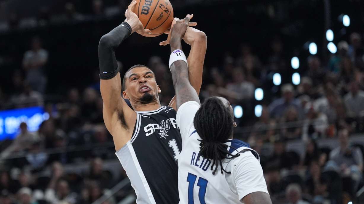 San Antonio Spurs forward Victor Wembanyama (1) grabs a rebound over Minnesota Timberwolves center Naz Reid (11) during the first half of Game 5 of an NBA basketball second-round playoffs series in Minneapolis, Tuesday, May 12, 2026.
