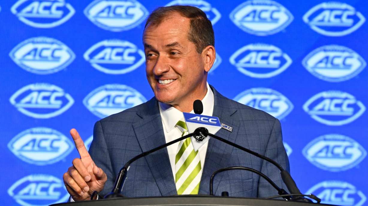 FILE - Atlantic Coast Conference commissioner Jim Phillips smiles during an NCAA college football news conference at the ACC media days, July 22, 2024, in Charlotte, N.C.