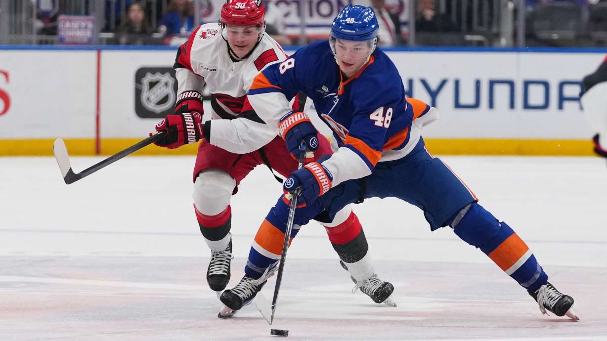 New York Islanders' Matthew Schaefer (48) drives past Carolina Hurricanes' Eric Robinson (50) during the second period of an NHL hockey game Tuesday, April 14, 2026, in Elmont, N.Y.