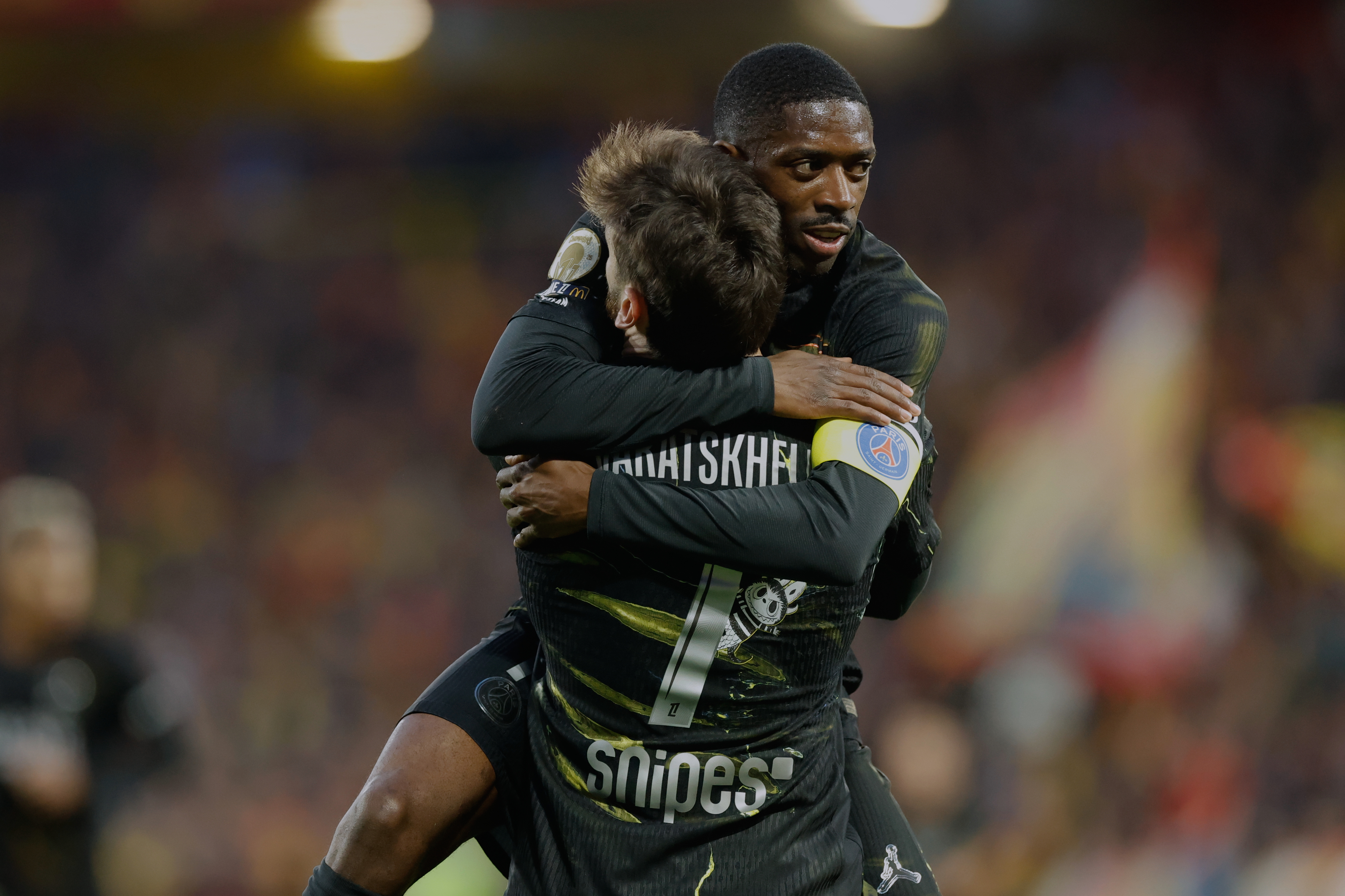 Khvicha Kvaratskhelia del Paris Saint-Germain celebra con su compañero Ousmane Dembele tras anotar un gol ante Lens en la liga francesa, el miércoles 13 de mayo de 2026. 