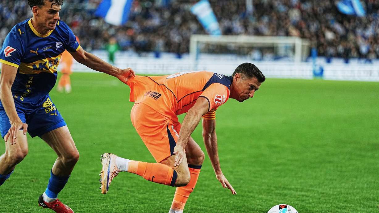 Barcelona's Robert Lewandowski, right, and Alaves' Angel Perez fight for the ball during the Spanish La Liga soccer match between Alaves and Barcelona in Vitoria-Gasteiz, Spain, Wednesday, May 13, 2026.