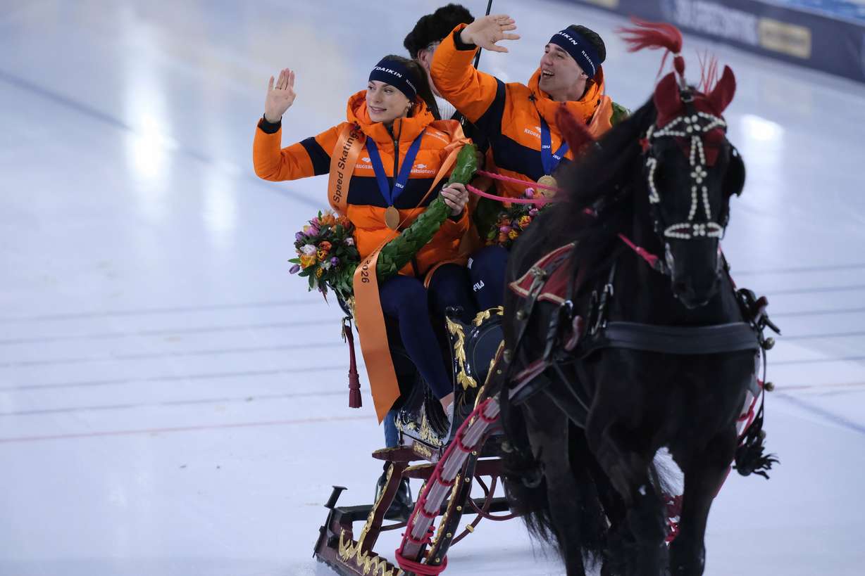 Femke Kok of the Netherlands and Jenning de Boo of the Netherlands ride a lap of honor in a horse-pulled sled after winning the World Championships Sprint in Heerenveen, Netherlands, March 8.