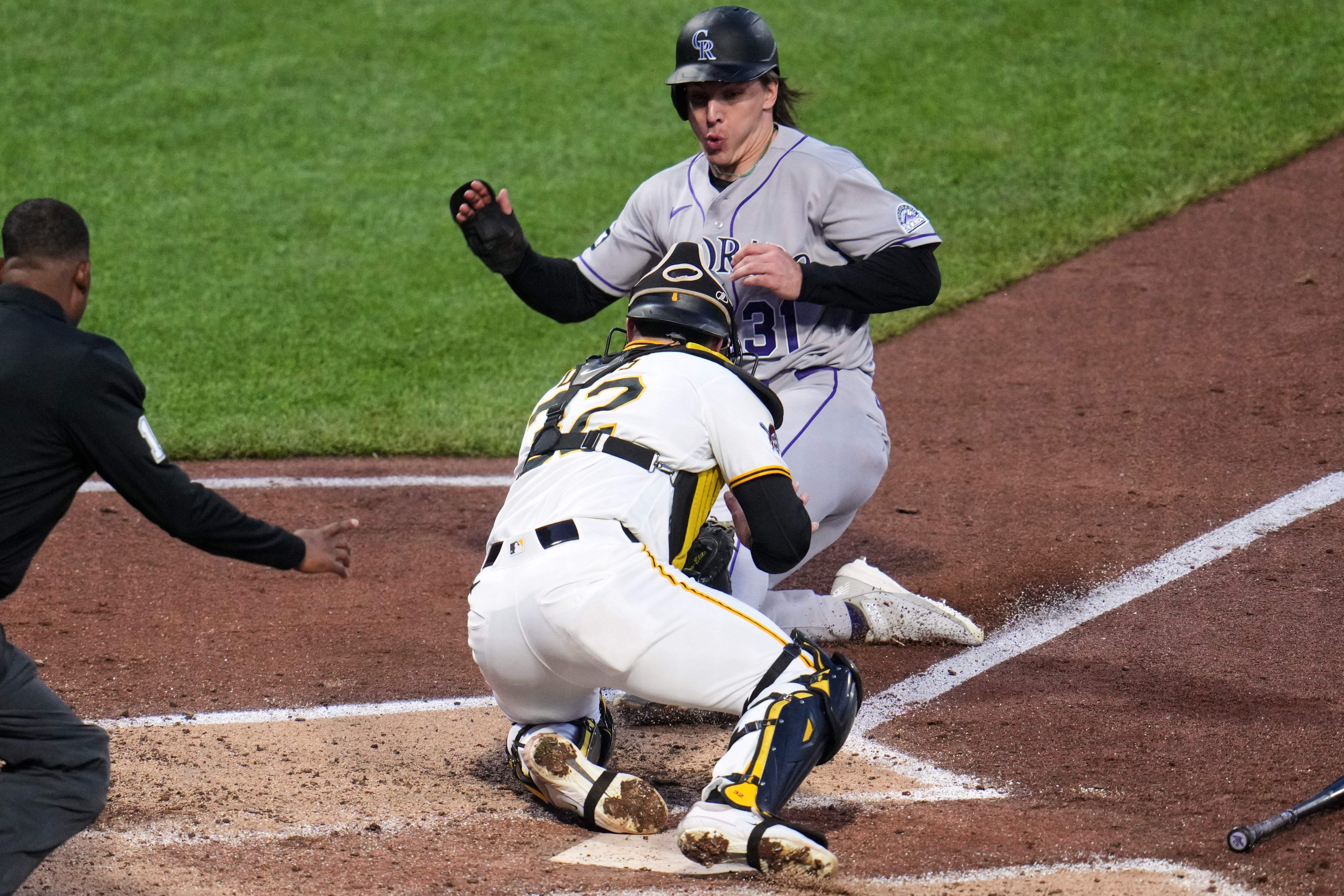 Colorado Rockies' Jake McCarthy, rear, is tagged out by Pittsburgh Pirates catcher Henry Davis attempting to score on a fielder's choice by Brett Sullivan during the fifth inning of a baseball game in Pittsburgh, Wednesday, May 13, 2026. 